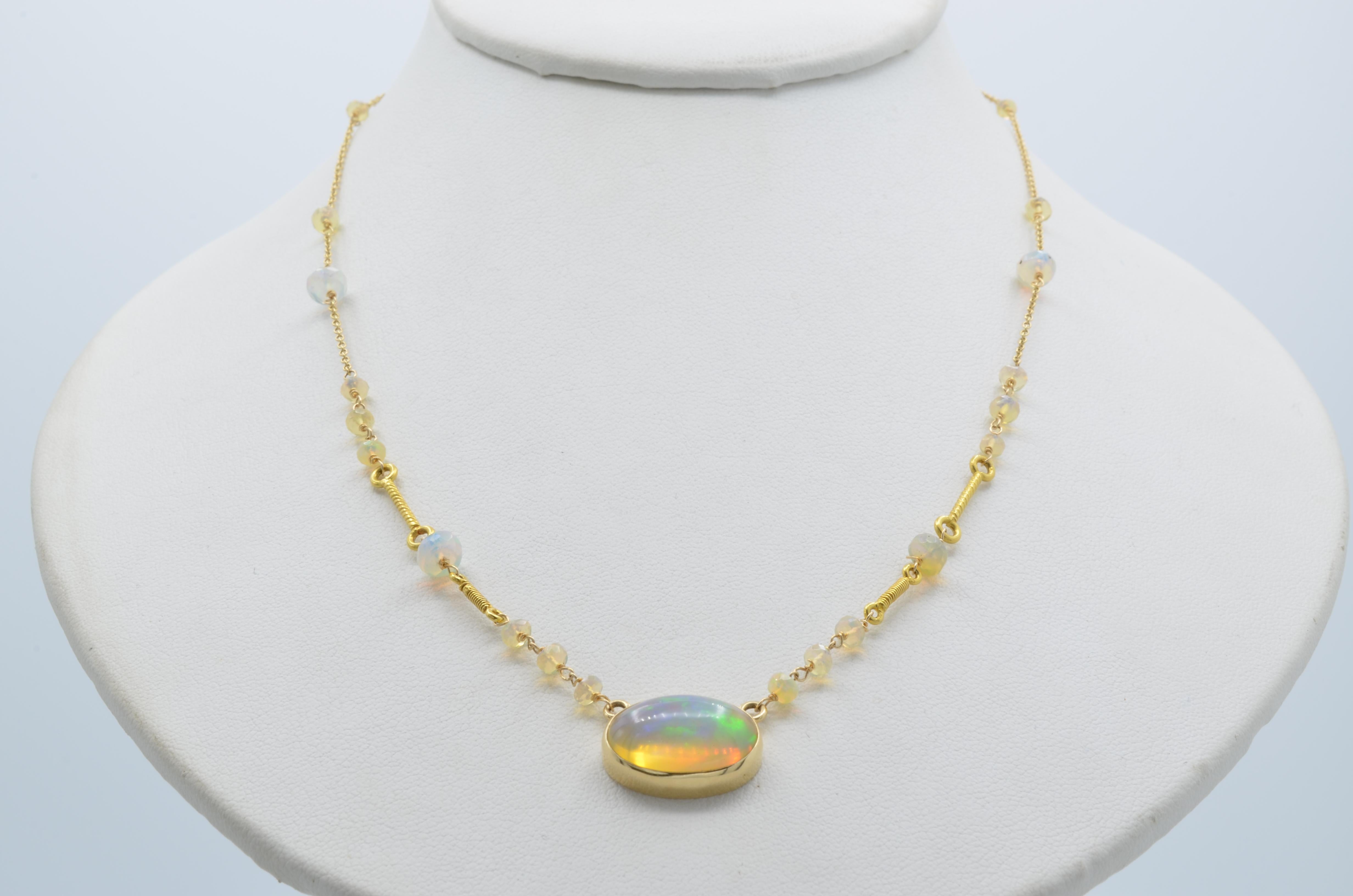 One large oval cabochon sits center on a 14K gold chain with alternating faceted opal beads. Intricately detailed, this regal necklace sings of beauty and elegance.