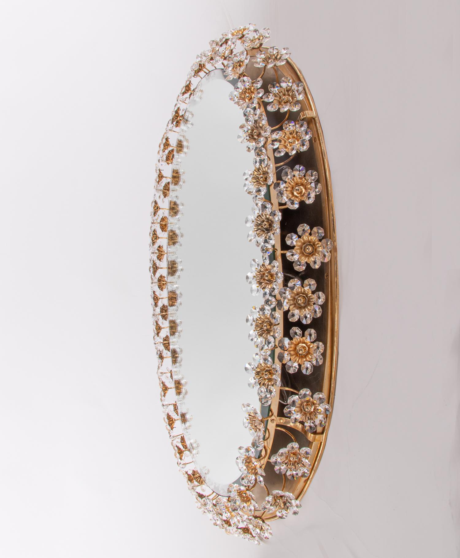 Elegant large illuminated oval backlit mirror with faceted crystals forming petals and flowers on a gilded brass frame. Desinged by Christoph Palme attr. Manufactured by Palwa, Germany, 1960s. 

Design: Christoph Palme attr. 
Model: Sputnik