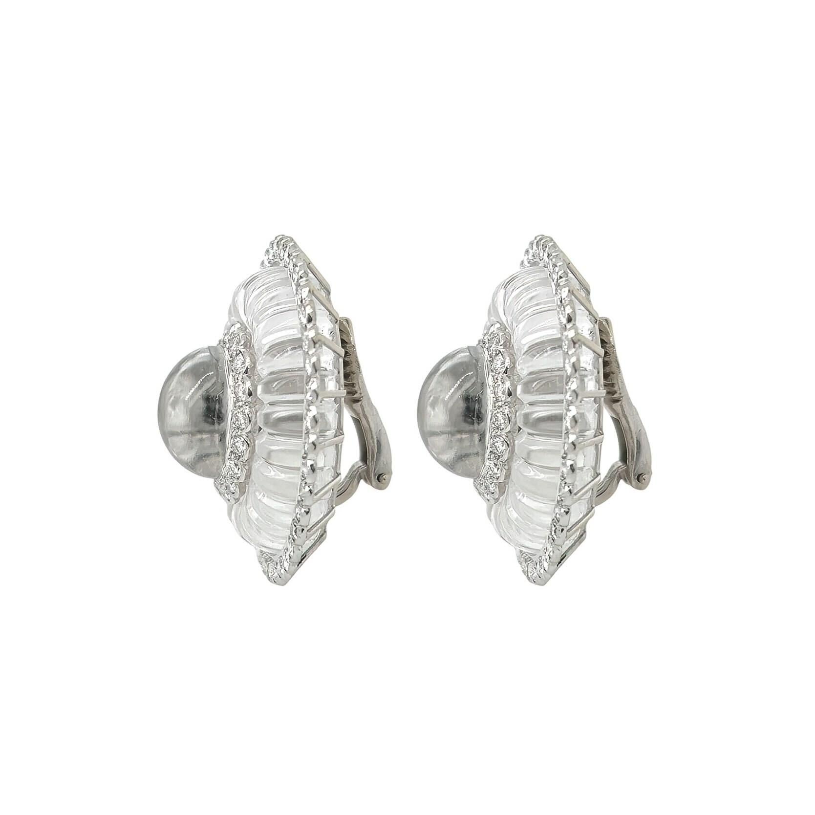 A pair of 14 karat white gold, platinum, rock crystal and diamond earclips.  Each white gold earclip centering an oval cabochon rock crystal surrounded by approximately 18 round brilliant cut diamonds within a fluted oval rock crystal surround