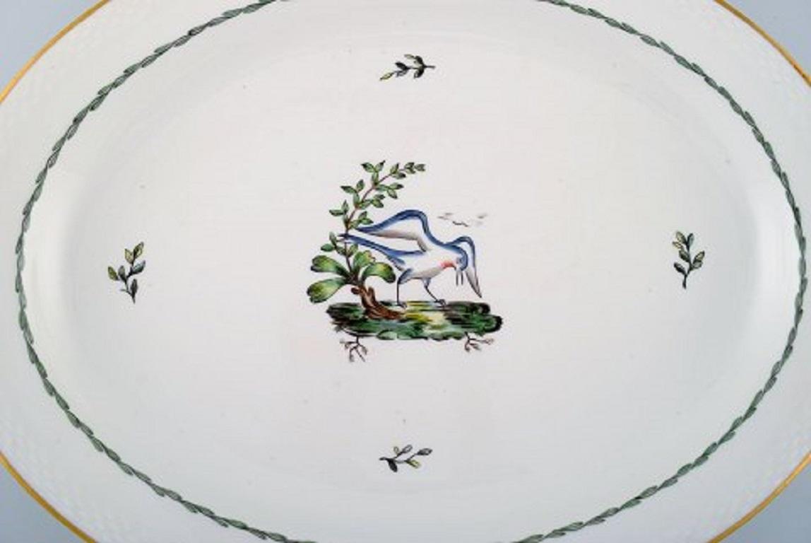 Large oval Royal Copenhagen serving dish in hand painted porcelain with bird motifs and gold decoration. 
Early 20th century.
Measures: 45.5 x 34.5 cm.
In very good condition.
Stamped.
2nd factory quality.