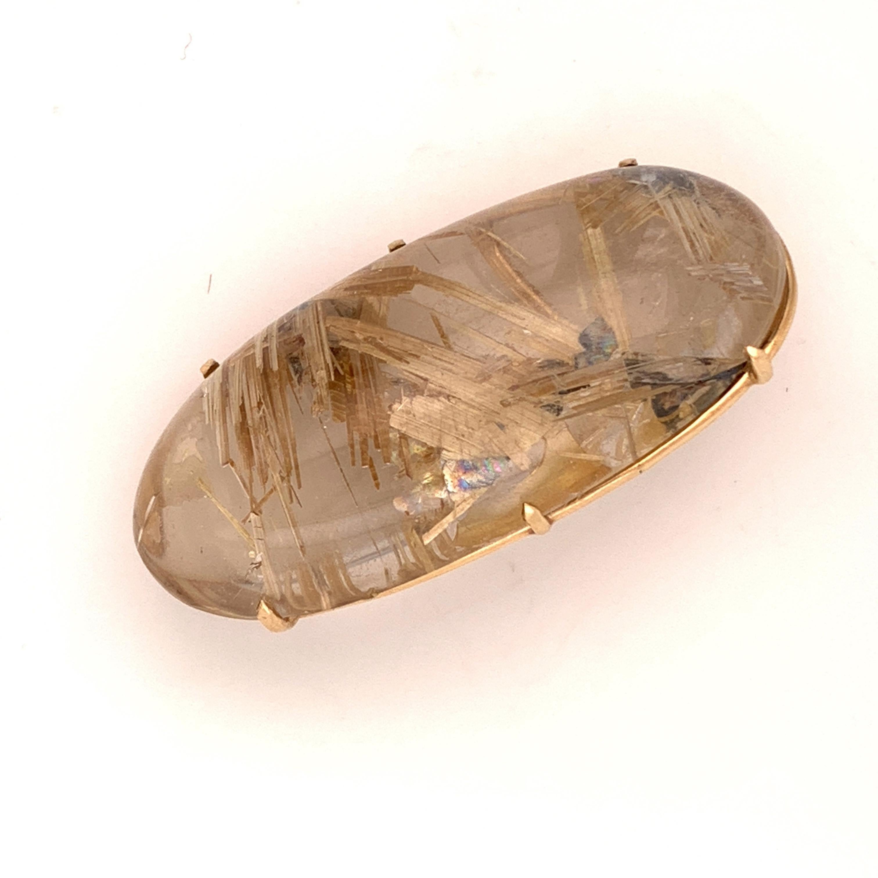 This stunning one of a kind brooch is versatile and can also be worn as a pendant. It features a big gorgeous rutilated quartz set in a six prong basket of 10K yellow gold. The striking clear stone looks as though it is threaded with gold and so it