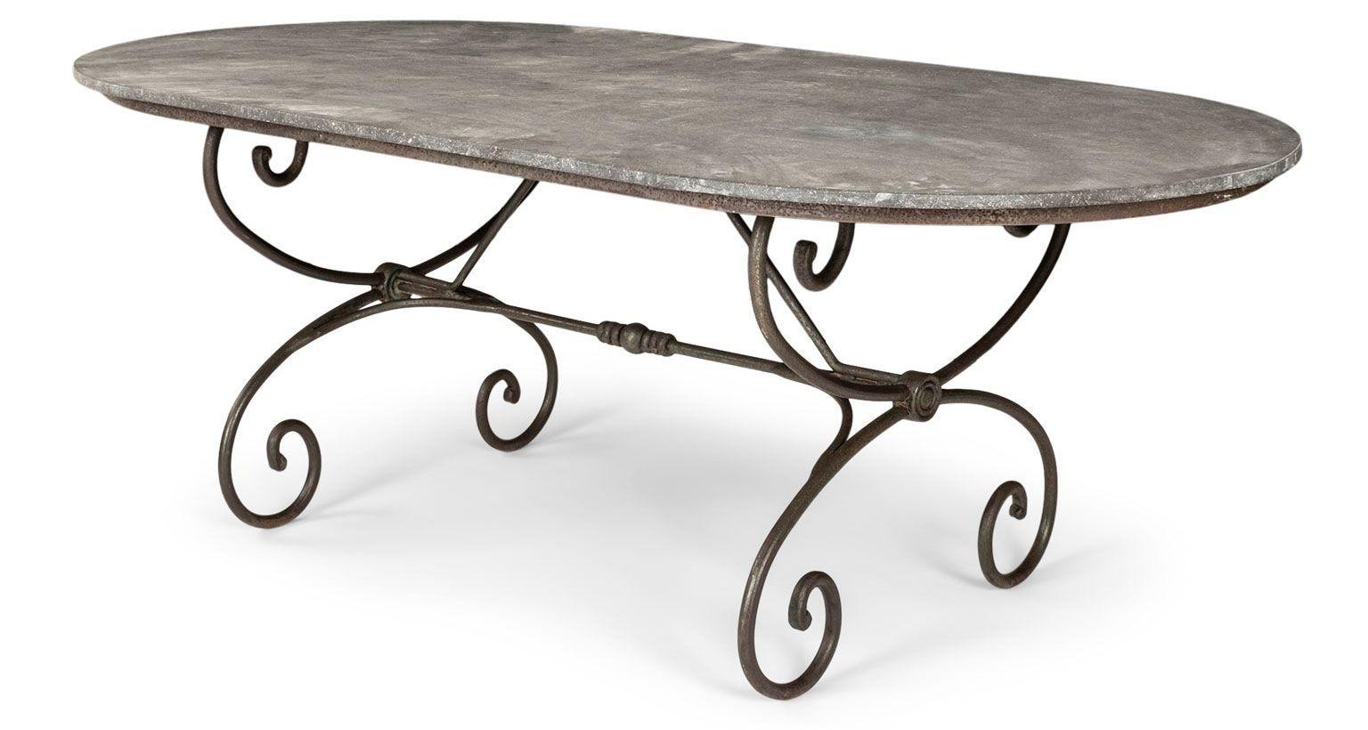 Large oval-shape Belgian bluestone top dining table raised upon scrolled iron base. Vintage dark bluestone top with unhoned texture from years of exposure and use. Late 19th century iron base from France.

Note: Original/early finish on antique and