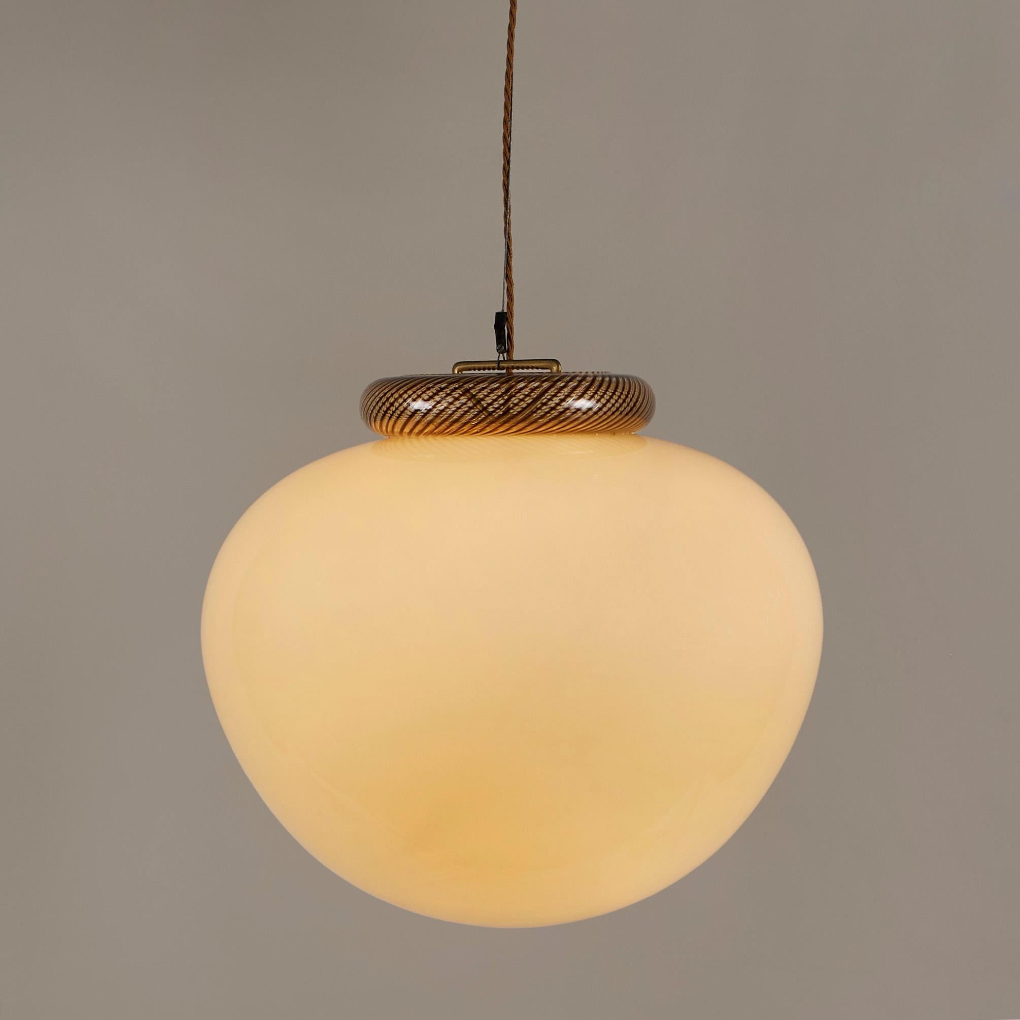 Substantial pendant in rich cream Murano glass with shaped clear and amber swirl top.