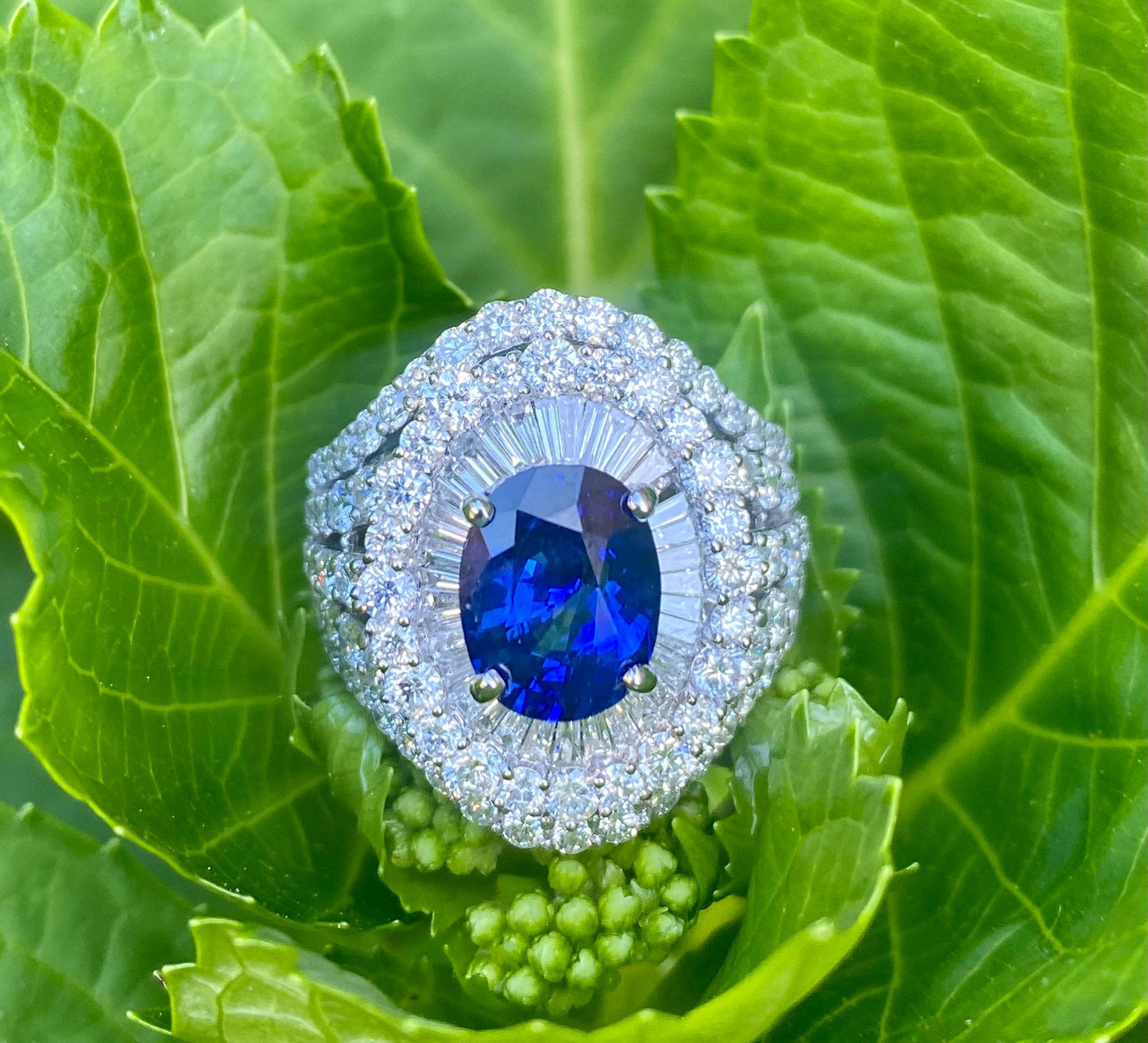 Magnificent estate large oval cut sapphire is prong set in 18 karat white gold and surrounded by prong-set baguette and round brilliant diamonds in a timeless and very elegant cocktail ring setting. The center sapphire is surrounded by baguette
