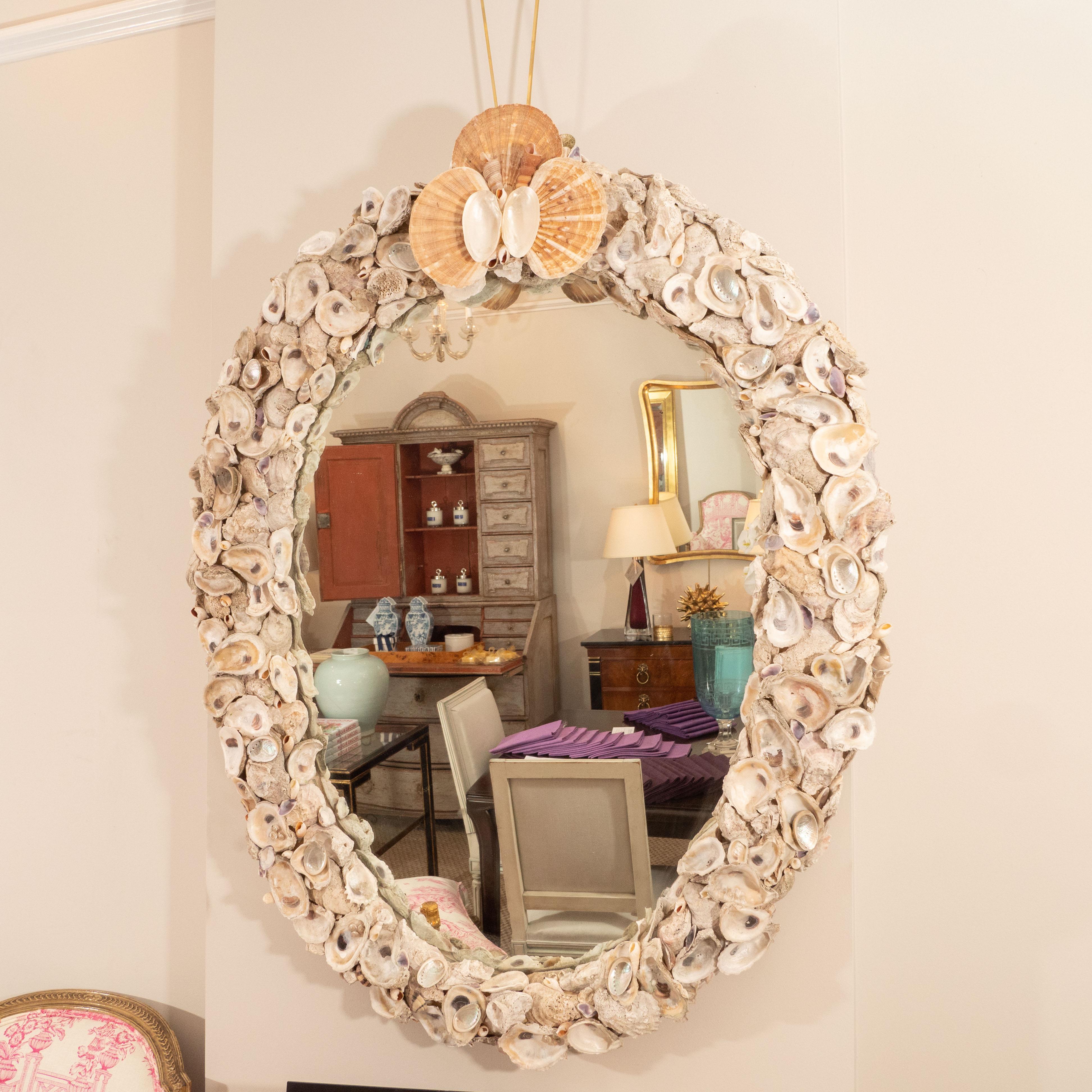 At a beach setting (or not!), this mirror is a statement piece! Large and oval in shape, the mirror is made up of sea shells (oysters, clams and others) with a large cluster at the top. We have seen a lot of examples of shell mirrors, but this one