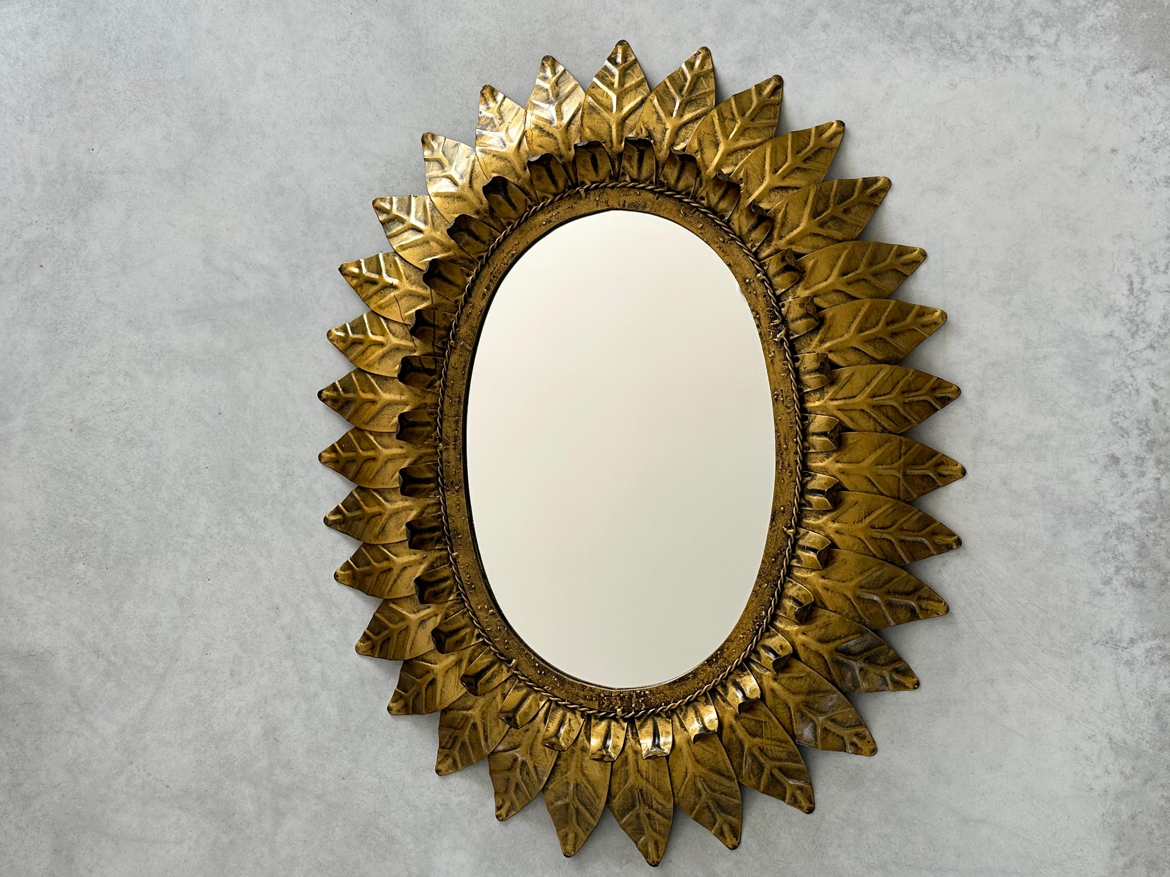 Big sunburst mirror in gold metal framed with gold-colored leaves.

This highly decorative oval sunburst mirror framed with elegant curved leaves in two sizes.

This mirror is in excellent vintage condition and has a beautiful aged patina.

General