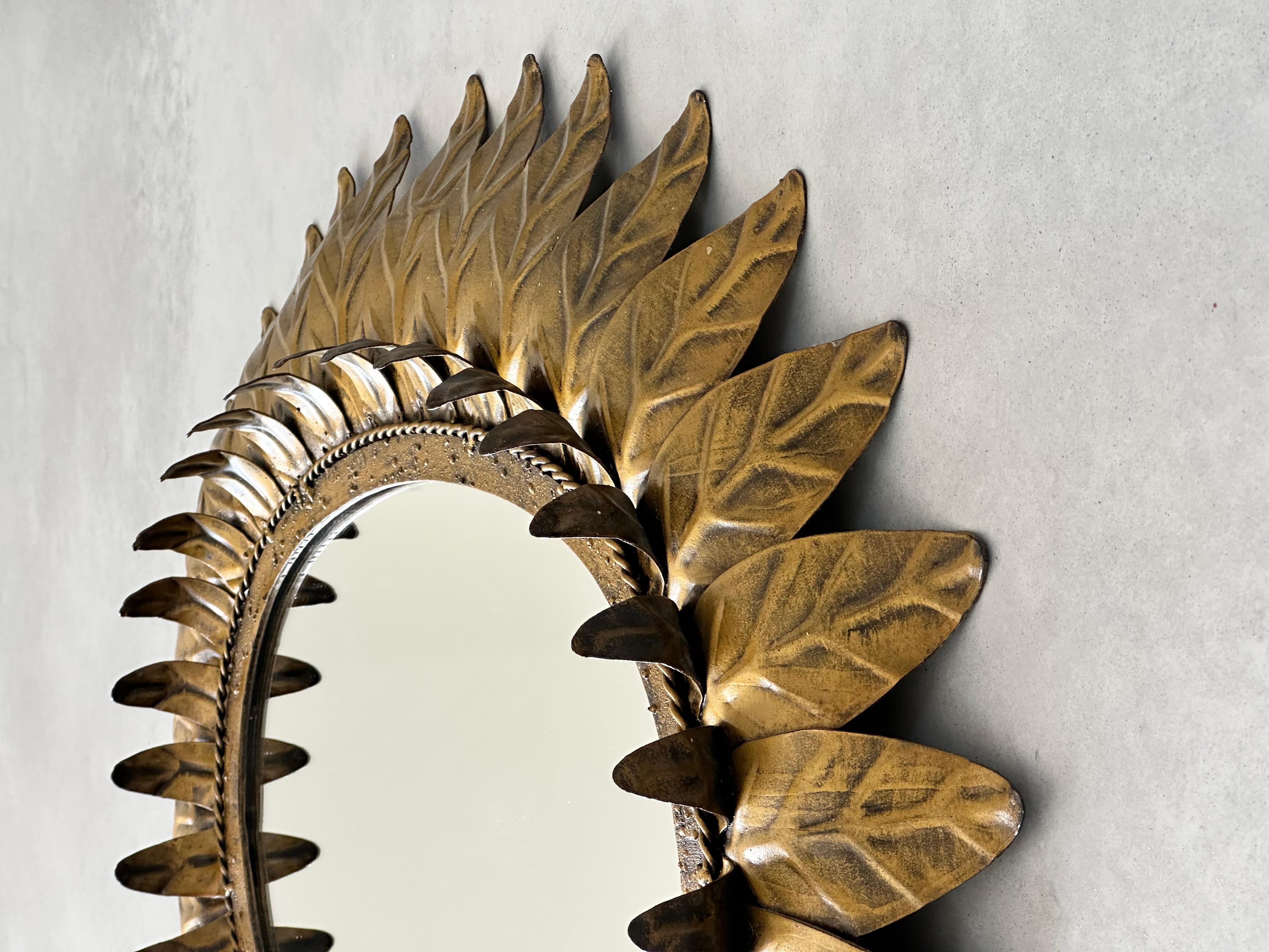 Spanish Large oval sunburst mirror, framed with gold-colored metal leaves, Spain 1960 For Sale