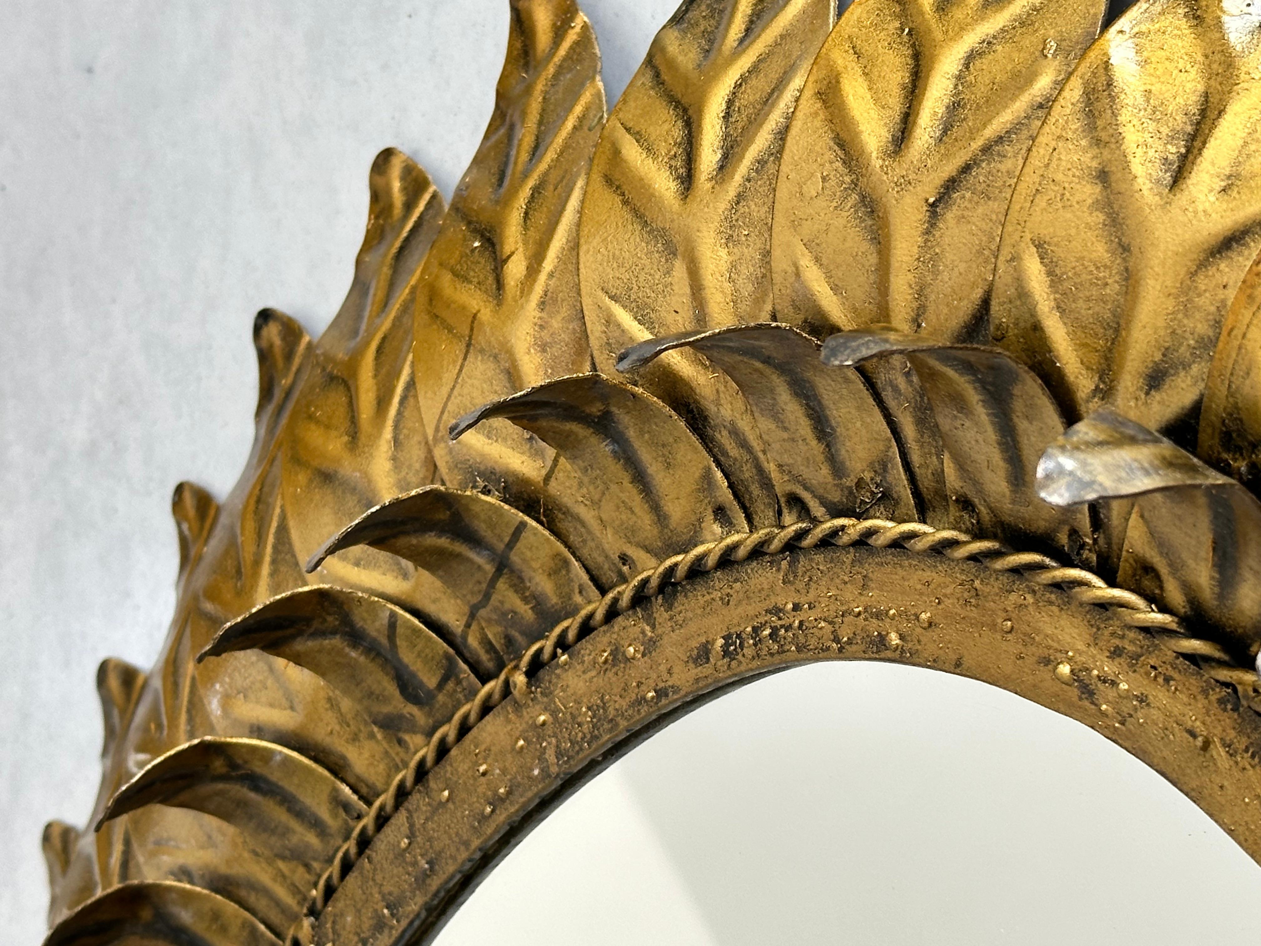 Large oval sunburst mirror, framed with gold-colored metal leaves, Spain 1960 In Good Condition For Sale In leucate, FR