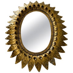 Grande specchio ovale a raggiera, incorniciato con foglie di metallo color oro, Spagna 1960
