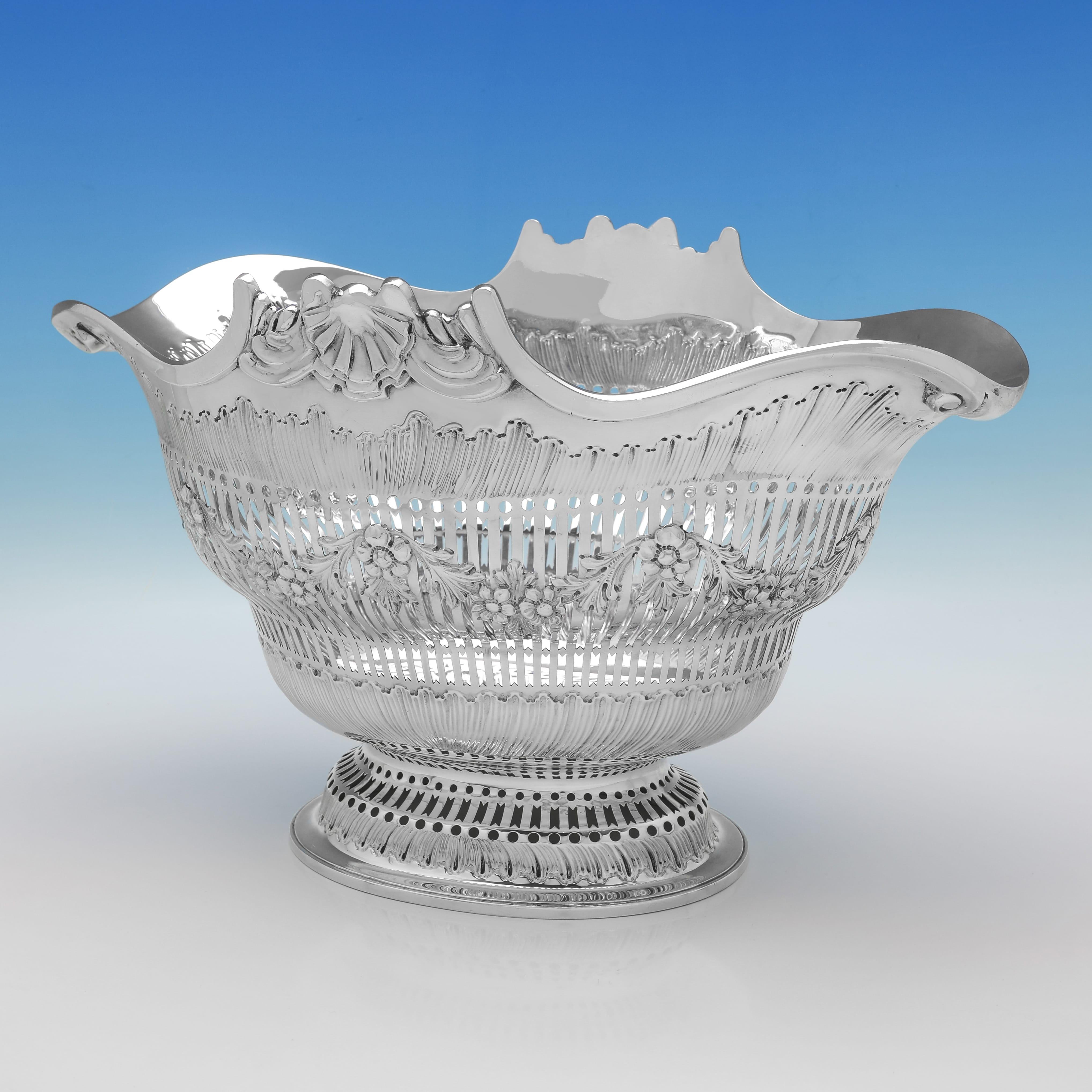 Siglato a Londra nel 1891 da Francis Boone Thomas, questo grande e imponente piatto antico in argento sterling è un ottimo esempio di artigianato tardo-vittoriano. Di forma ovale e di proporzioni generose, il pezzo è traforato e decorato dappertutto