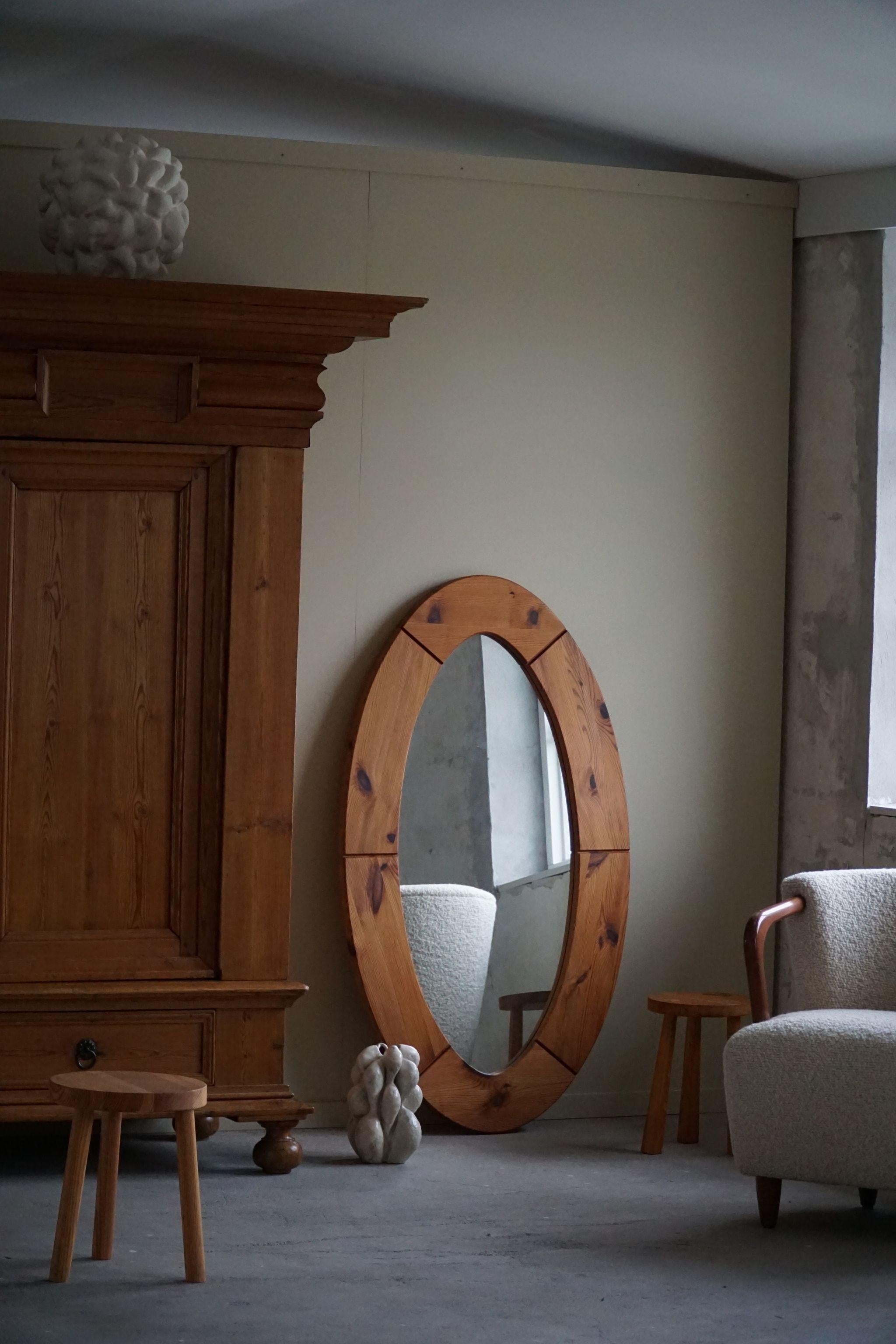 A beautiful large oval wall mirror in solid pine. Made by Glasmäster in Markaryd, Sweden in the 1960s. A decorative object that pairs well with many types of interior styles. A Modern, Scandinavian, Classic or an Art deco home decor.

A warm colour