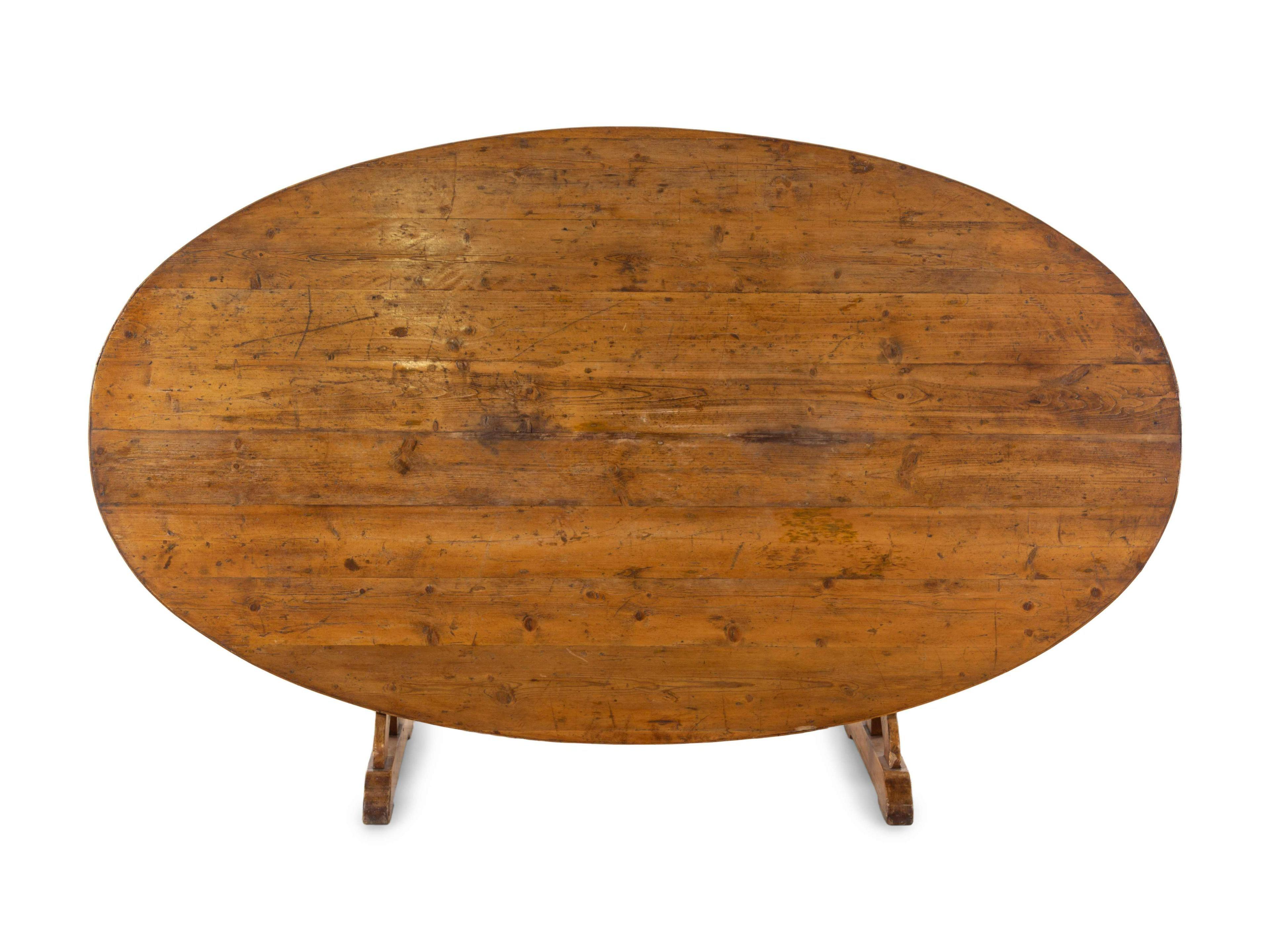 An unusually large oval wine tasting table in pine, circa 1850, French. The top tilts and is supported by a harp shaped brace that rotates. These were used in wine caves to entertain at a moment's notice.