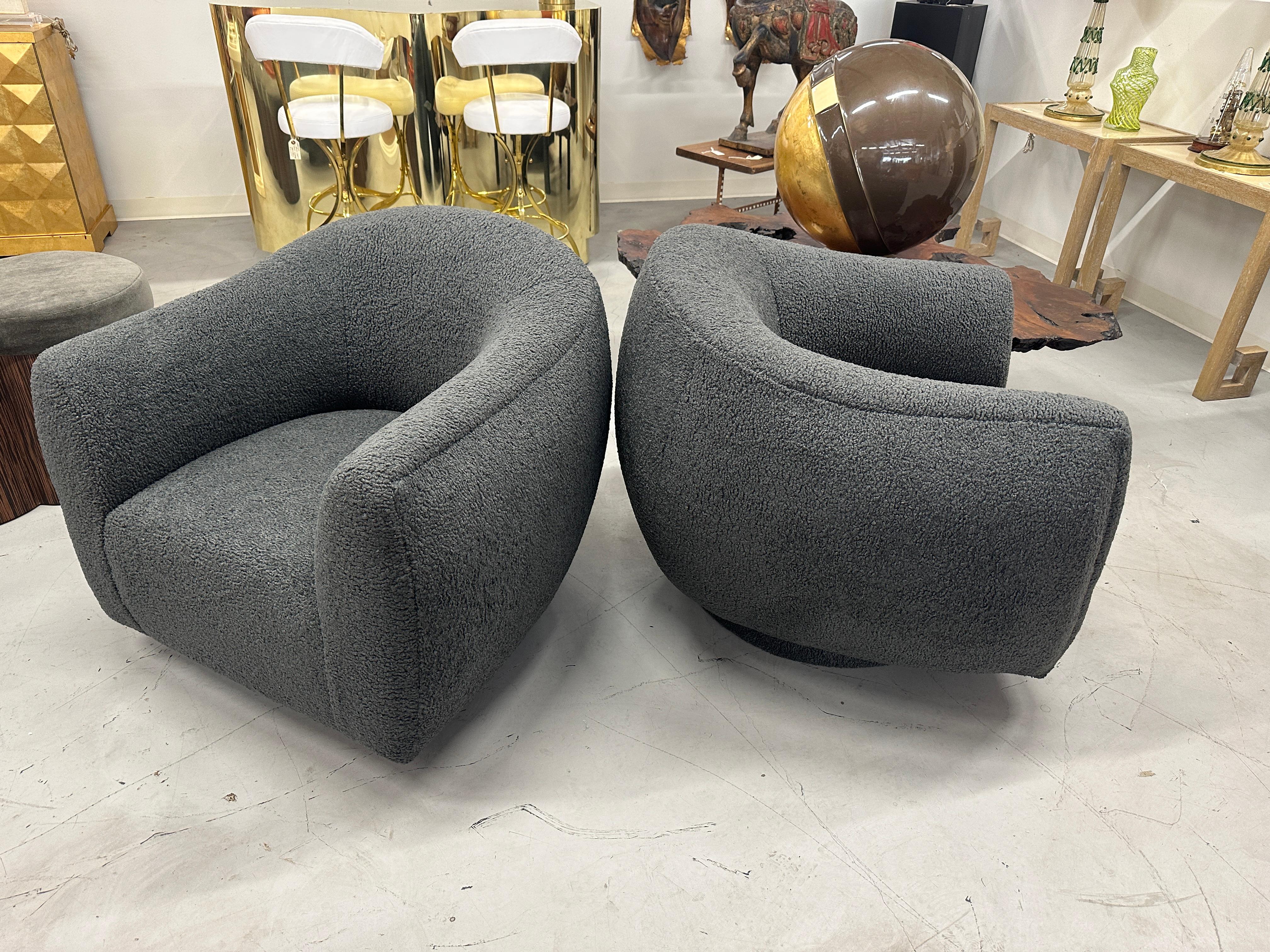 Wonderful pair of oversized A. Rudin swivel chairs we bought out of a lovely Palm Springs Estate a while back and had reupholstered and had made more generous. We had them redone in a lovely Italian grey boucle. The round bases are upholstered.