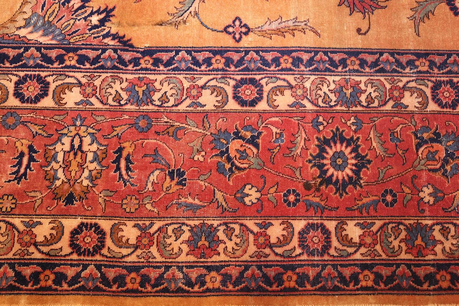 All-over design large oversized antique Indian carpet, country of origin: India, Circa Date: 1920. Size: 14 ft x 24 ft 6 in (4.27 m x 7.47 m)

A wealth of crisply detailed floral designs fills the honey-hued center of this antique Indian rug, lush