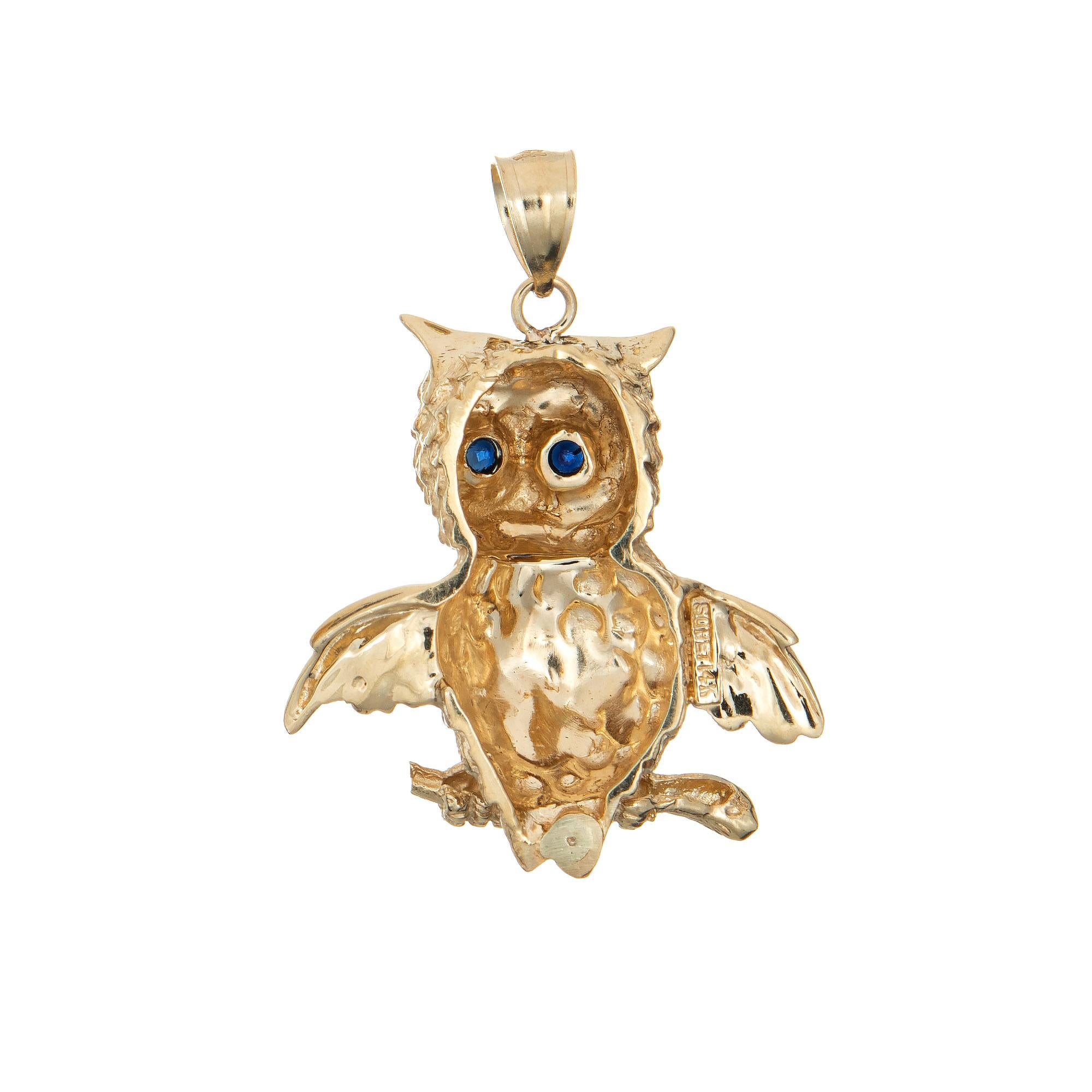 Finely detailed vintage owl pendant crafted in 14k yellow gold (circa 1970s to 1980s).  

Two estimated 0.05 carat sapphires are set into the eyes (0.10 carats total estimated weight). 

The charming & whimsical owl sits perched on a branch with