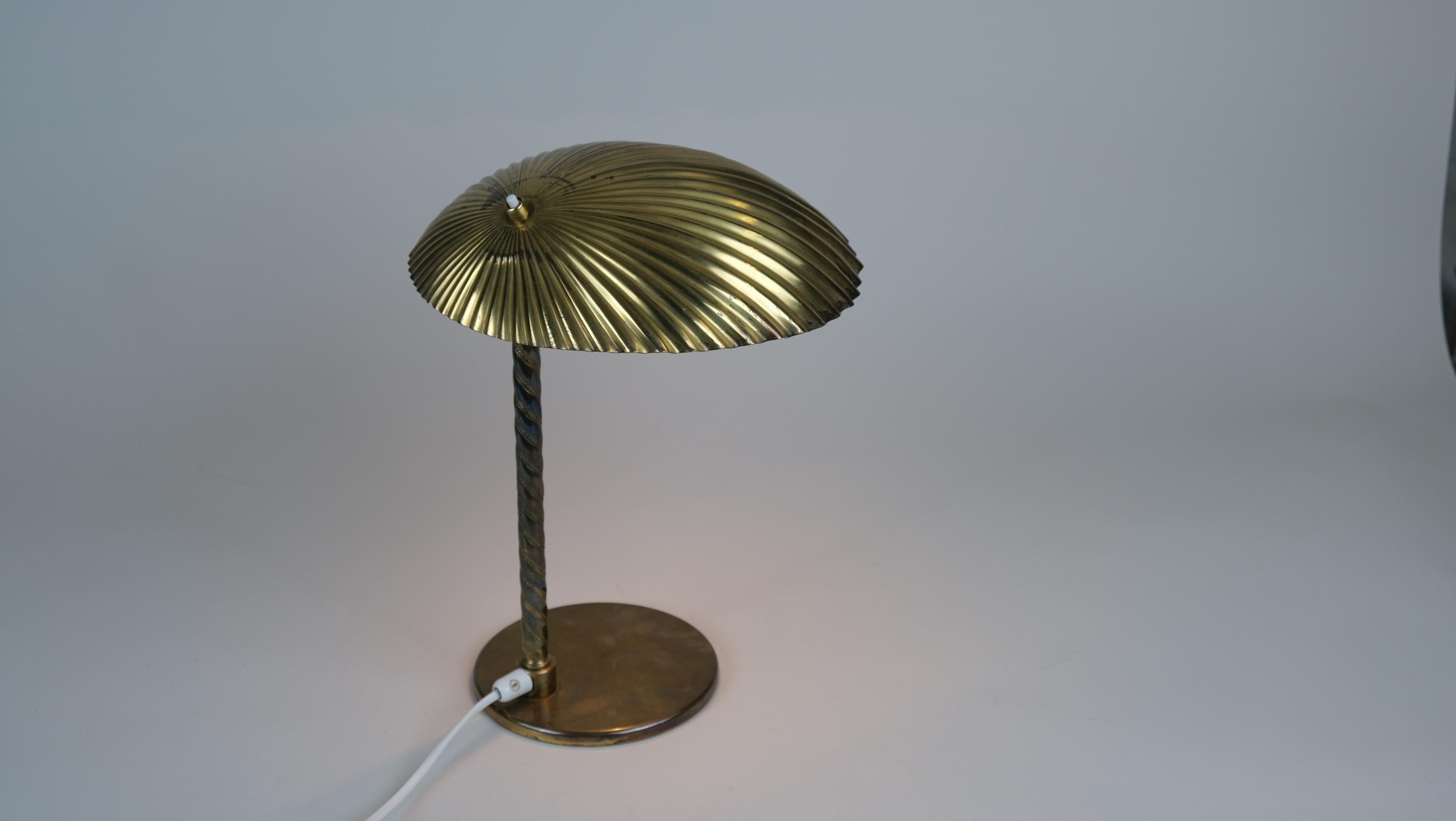 A gorgeous and possibly unique seashell lamp by Paavo Tynell in full brass and larger than the usual versions seen in the market. The leg is in full brass rather than the usual rattan seen on this model. Tynell used different kinds of materials on