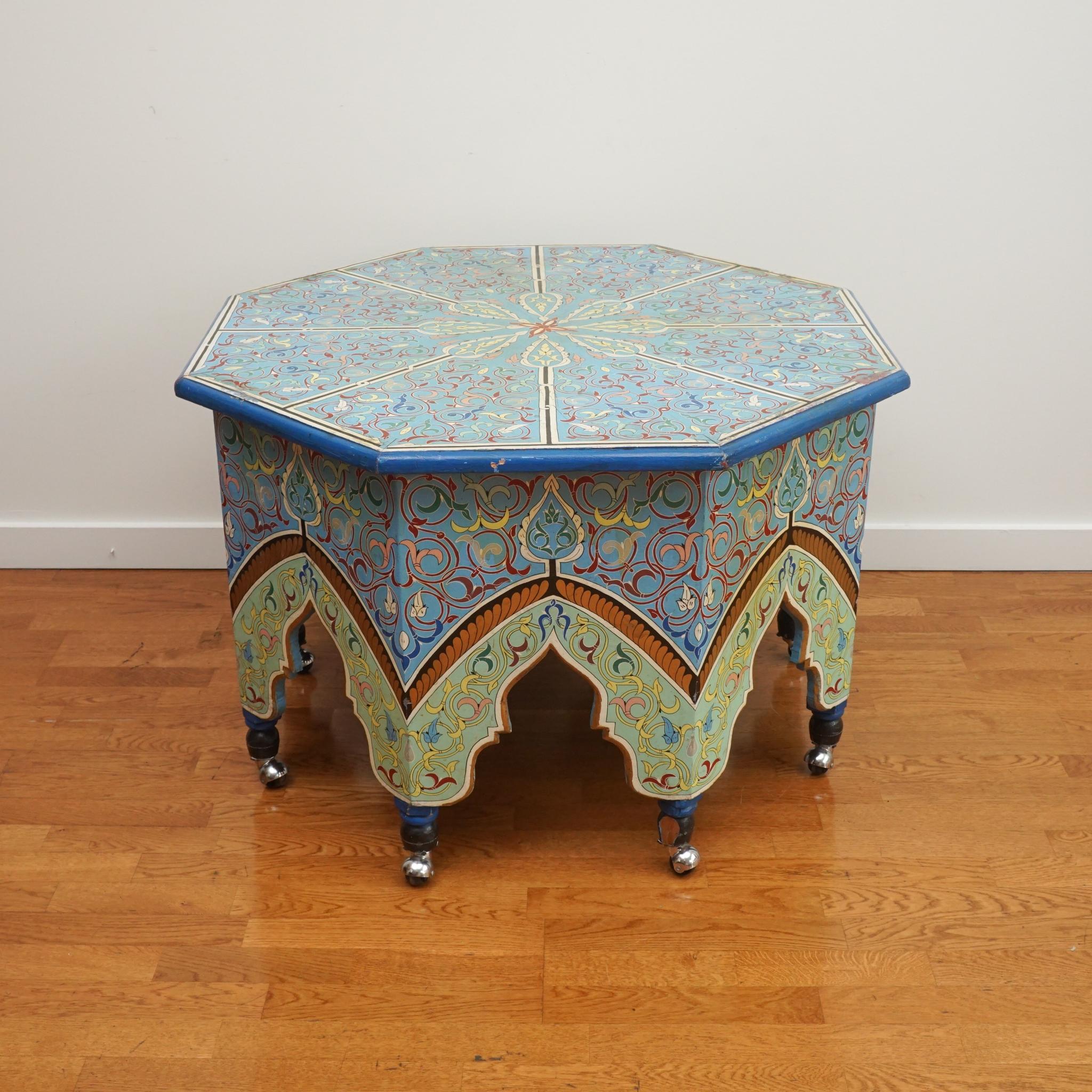 The octagonal-shaped Moroccan-style table, shown here, is notable for its design, pattern and color. Intricately painted top to bottom, the table is mounted on casters and exhibits rich color given its age.