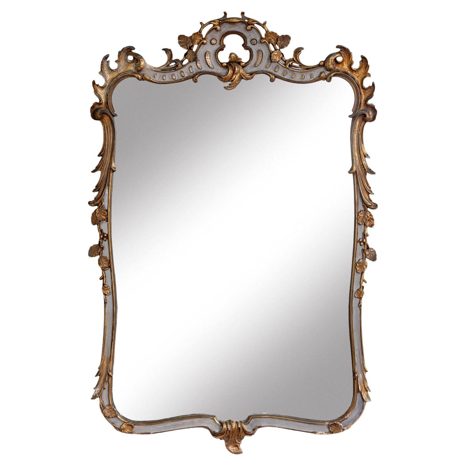 Grand miroir en bois peint et doré, écusson orné, début du 20e siècle