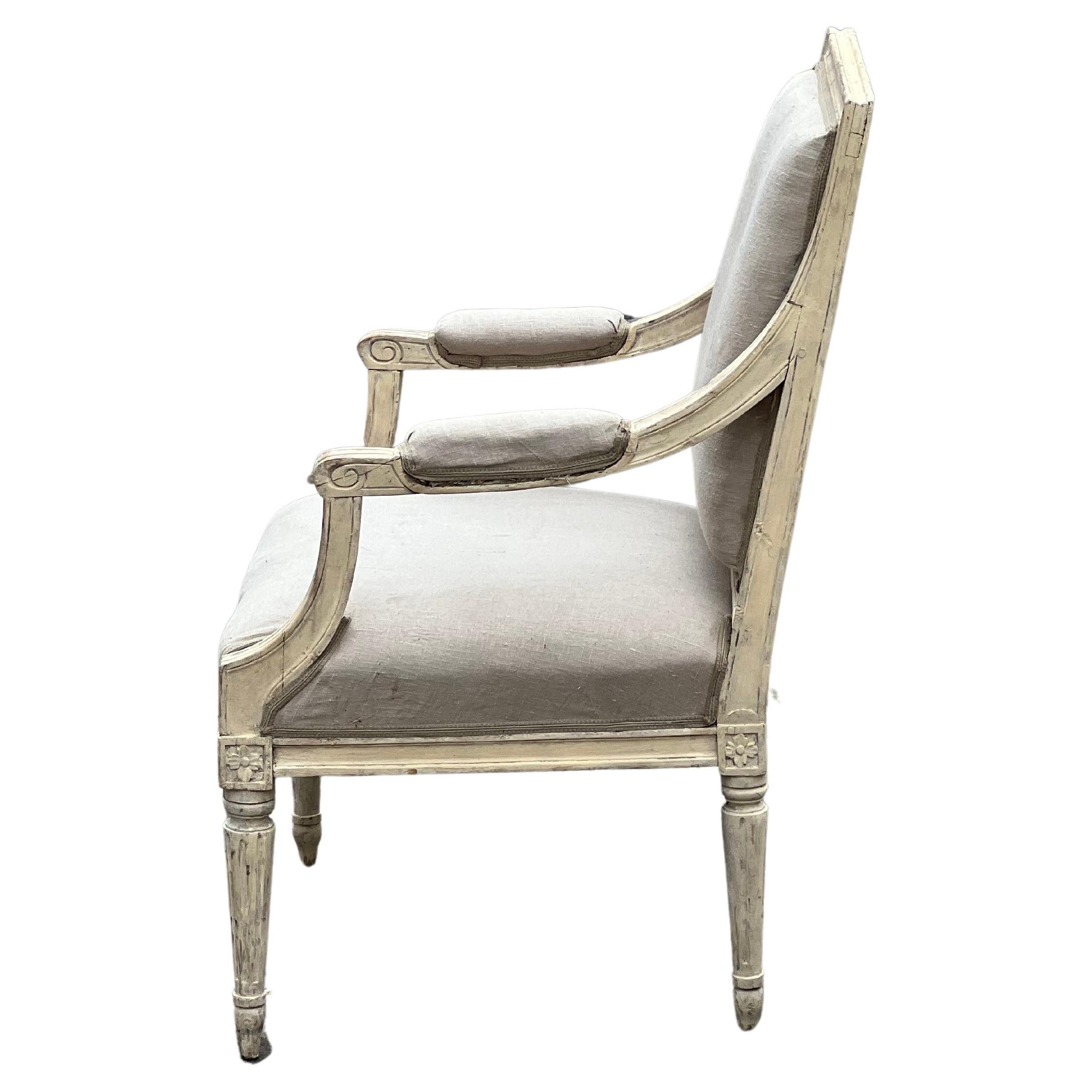 A large period Gustavian armchair with wood carved decor. The chair is unmarked, but is a typical example of a Stockholm Master work around 1780. The piece stands out with a beautiful, natural patina, exquisitely carved flower motifs in the front,