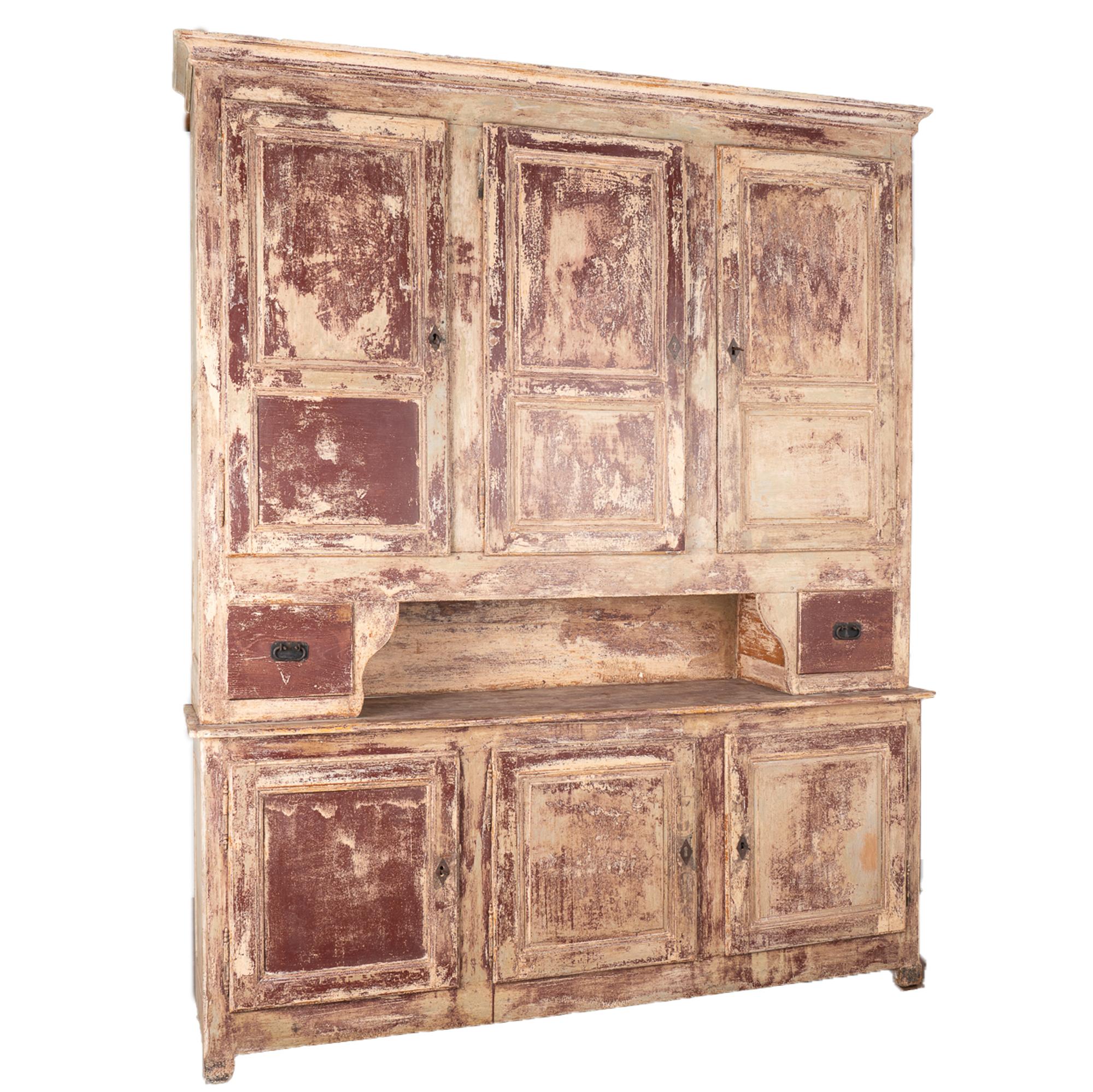 This amazing French country pine shop cabinet is from the late 1800's and stands 9.5' tall.
Newer custom painted layered finish in burgundy with a white interior, distressed fitting the age of this impressive cabinet.
The unique configuration of