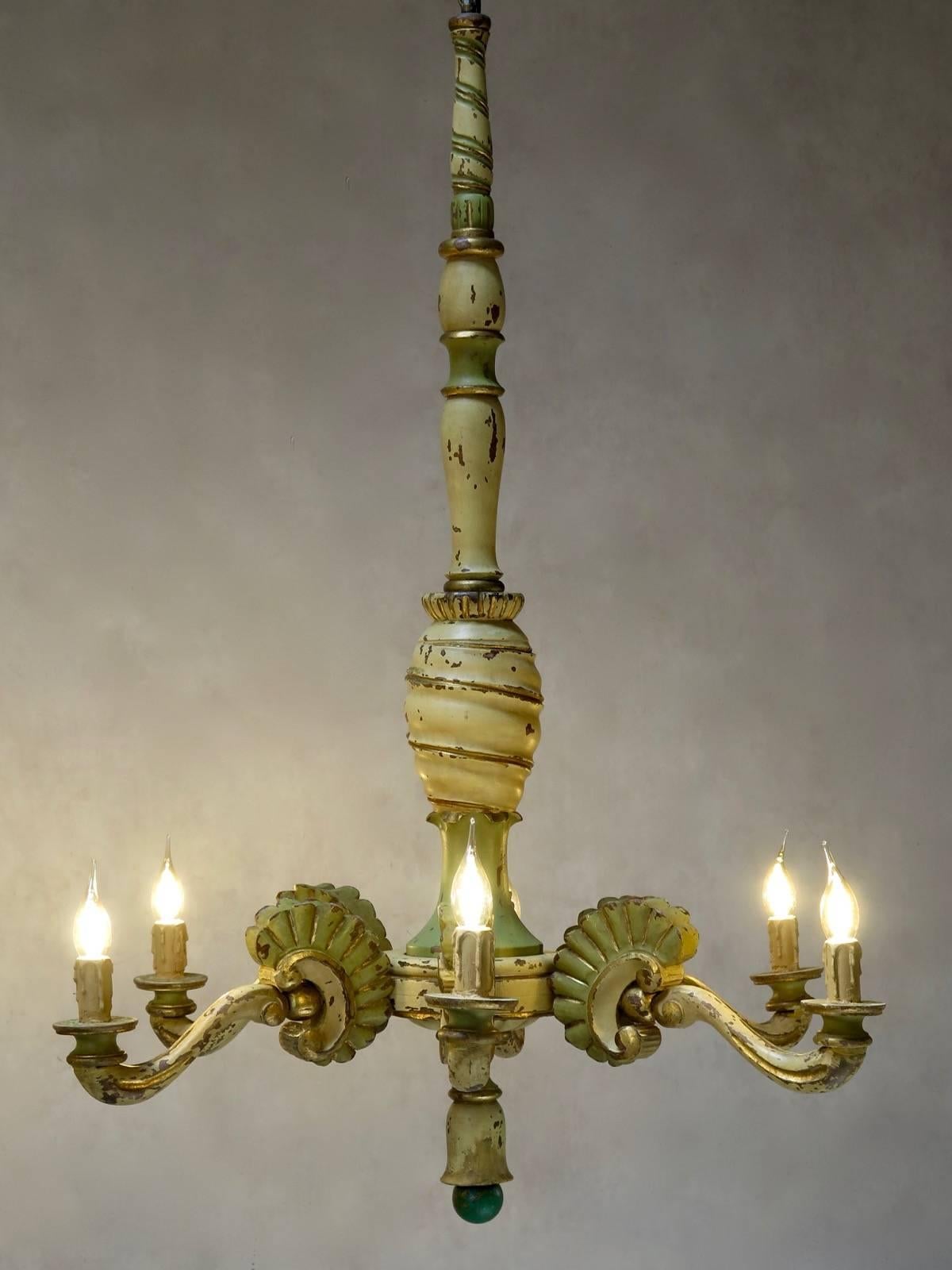 Rare and beautifully-carved wood chandelier, with six arms. With original pale green, cream and gold paint.