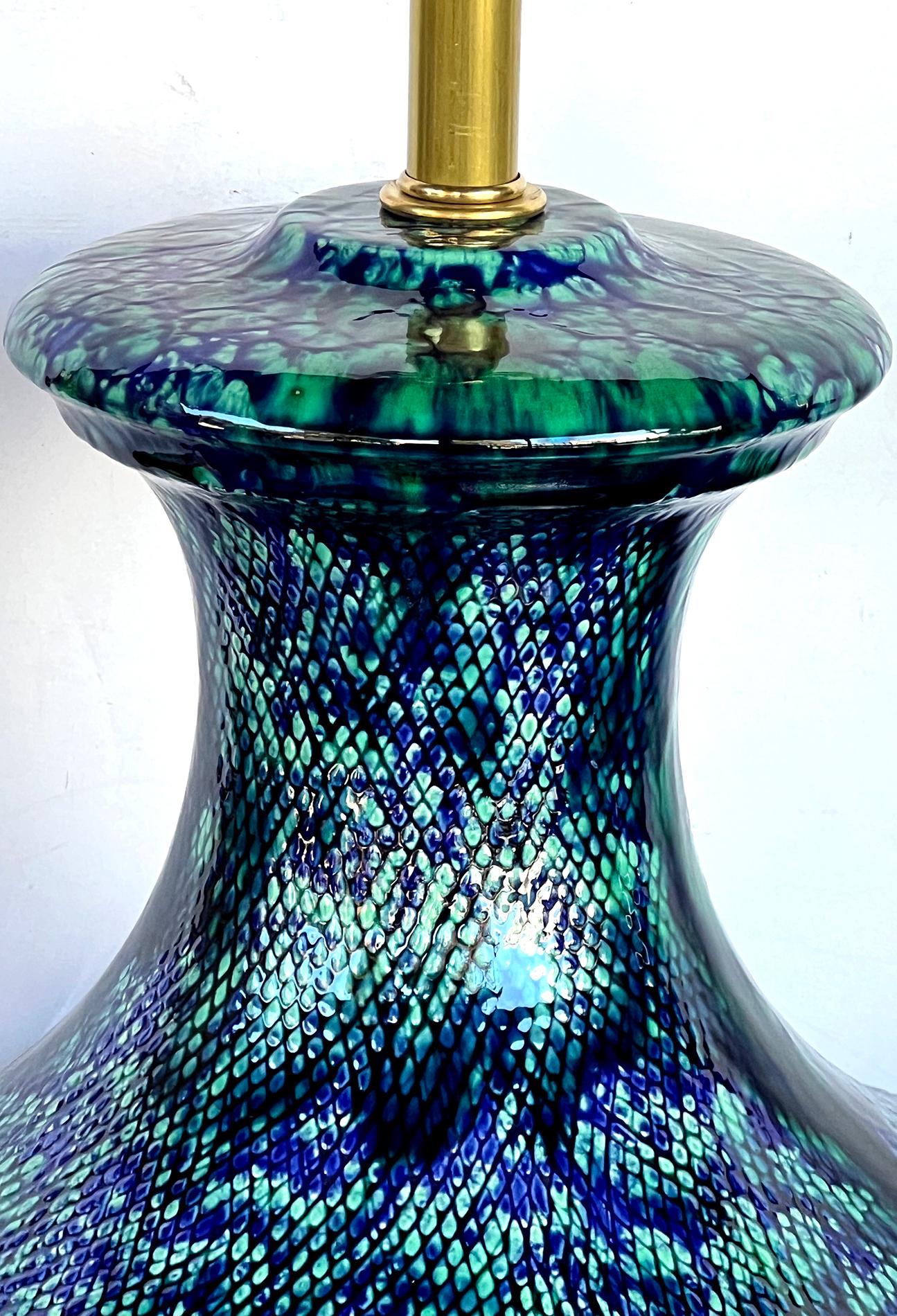 each with flaring neck above a bulbous body; the textured surface covered in a deeply colored blue and teal drip glaze