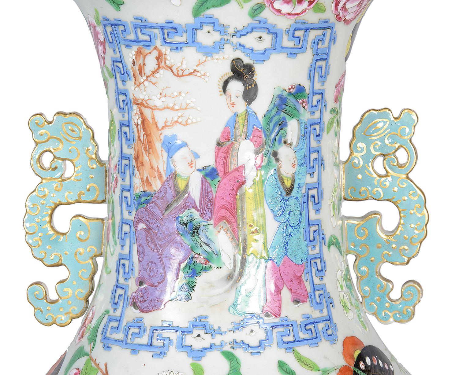A very impressive pair of 19th century Chinese rose medallion / cantonese two handled vases. Each with wonderful bold coloring to the inset painted panels depicting interior scenes of courtiers and their attendants, bordered by classical motif,