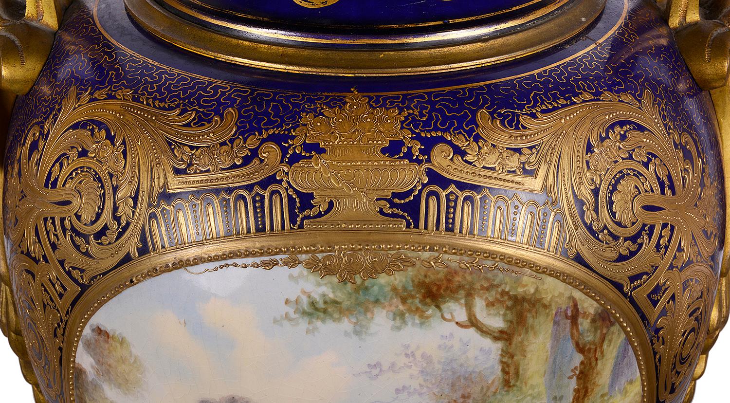 Grande paire de vases en porcelaine française de style Sèvres de la fin du XIXe siècle, de bonne qualité, chacun doté d'une magnifique anse en bronze doré et d'un feuillage de chaque côté, sur fond bleu cobalt, avec un décor classique doré. Panneaux