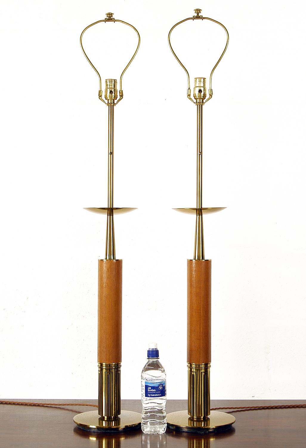 A substantial pair of American Mid-Century Modern table lamps by The Stiffel Lamp Company of Chicago, USA. Made of teak and brass, these incredibly stylish lamps stand an impressive 110cm tall to the top of the harp finial and 113cm to the top of