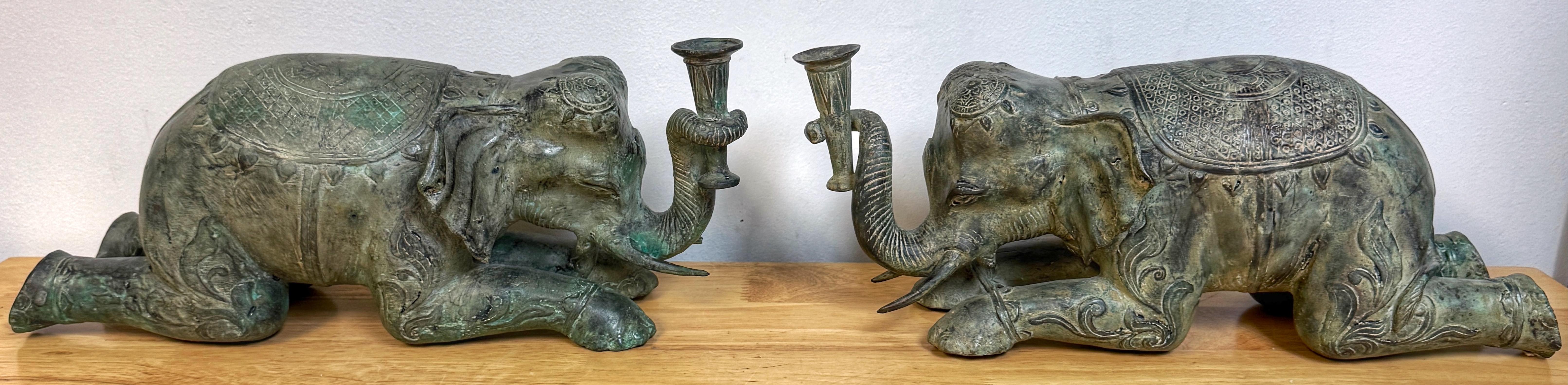 Large Pair Asian Bronze Recumbent Processional Elephant Motif Candlesticks, Later 20th Century, Attributed to the workshops of Sarried Ltd.

A magnificent large pair of Asian bronze recumbent processional elephant motif candlesticks, attributed to