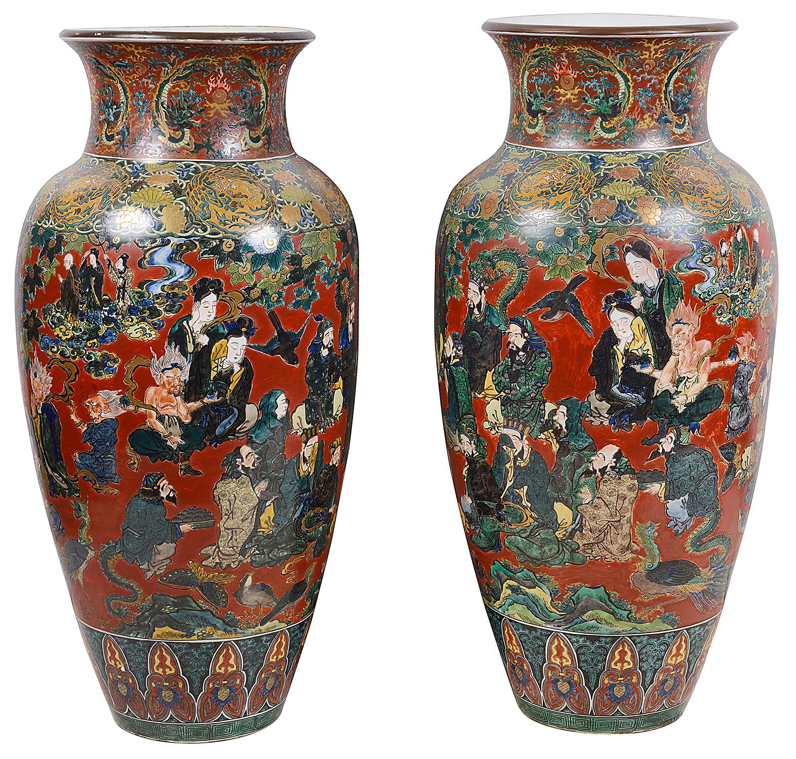 Une magnifique paire de vases en porcelaine Kutani de la période Meiji (1868-1912). Magnifiques images peintes à la main d'assistants se réunissant le matin, décorées de motifs classiques en haut et en bas, signées sur les bases. Taille : 100cm
