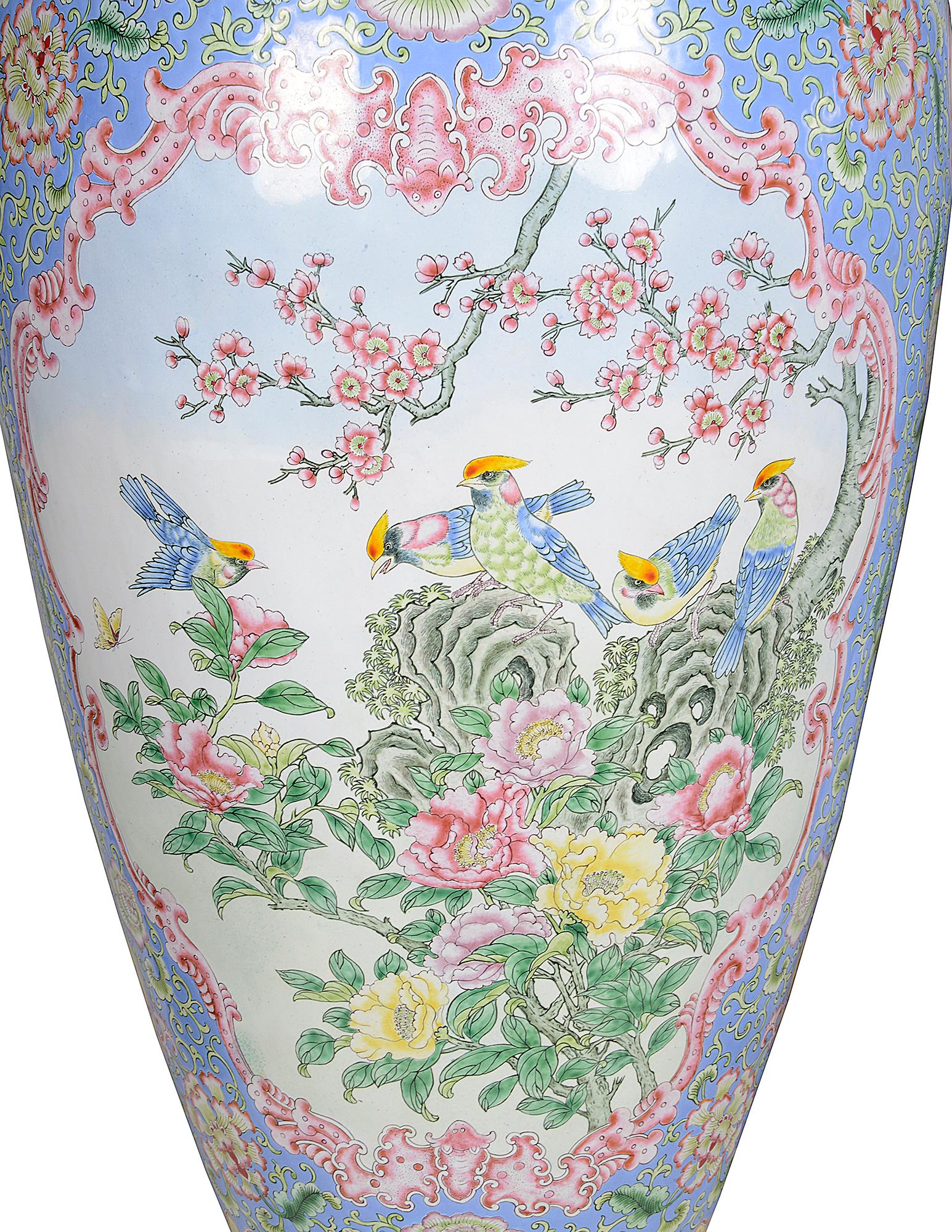 A very impressive pair of late 19th century Chinese Canton enamel vases, each with wonderful pastel colours, with a powder blue ground exotic floral decoration, inset panels depicting birds in the blossom trees.