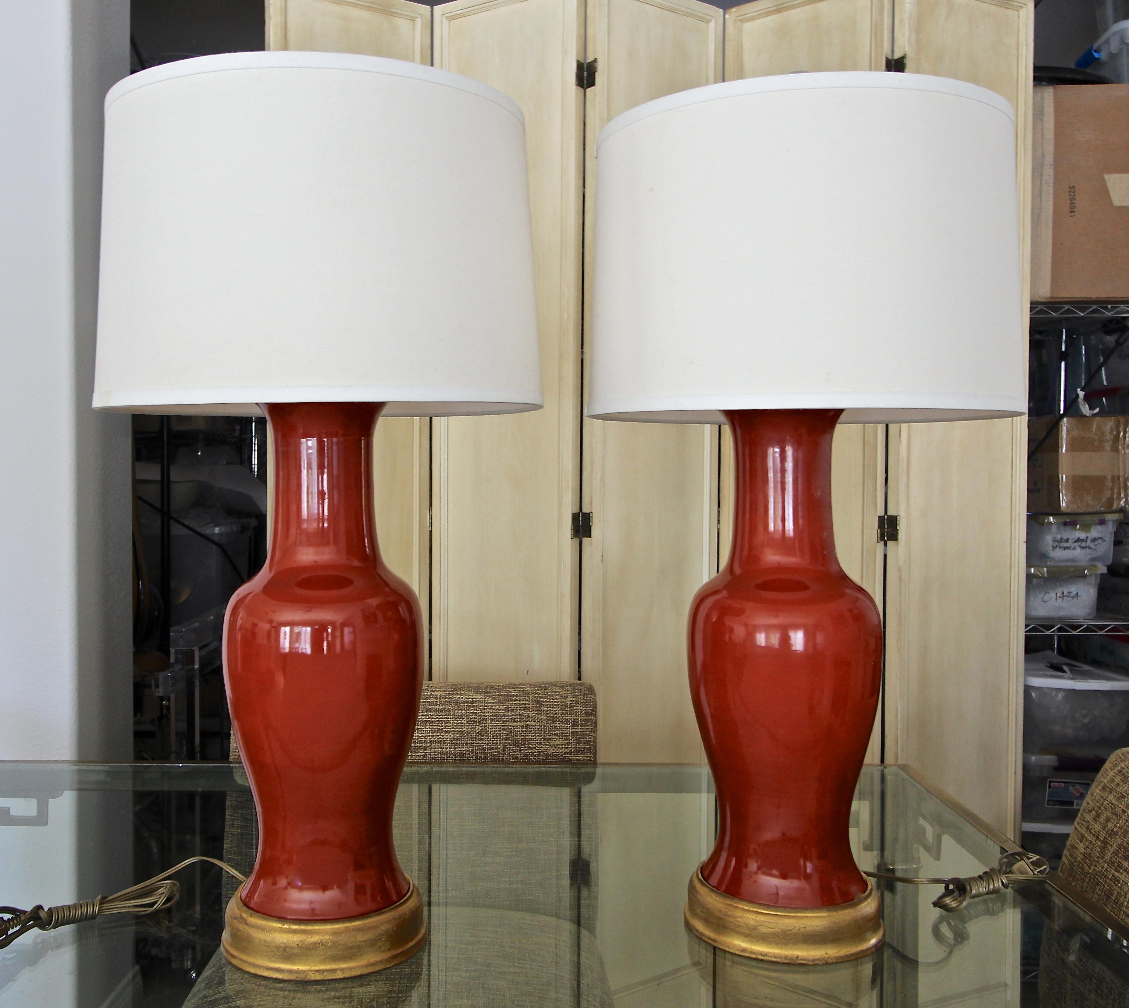 Pair of large scale Asian burnt orange porcelain baluster form vases mounted on gilt turned wood lamp bases. Interior vase cap is also turned wood in a gilt finish. Newly wired with new 3 way brass sockets and cords. Shades not included.
Vase