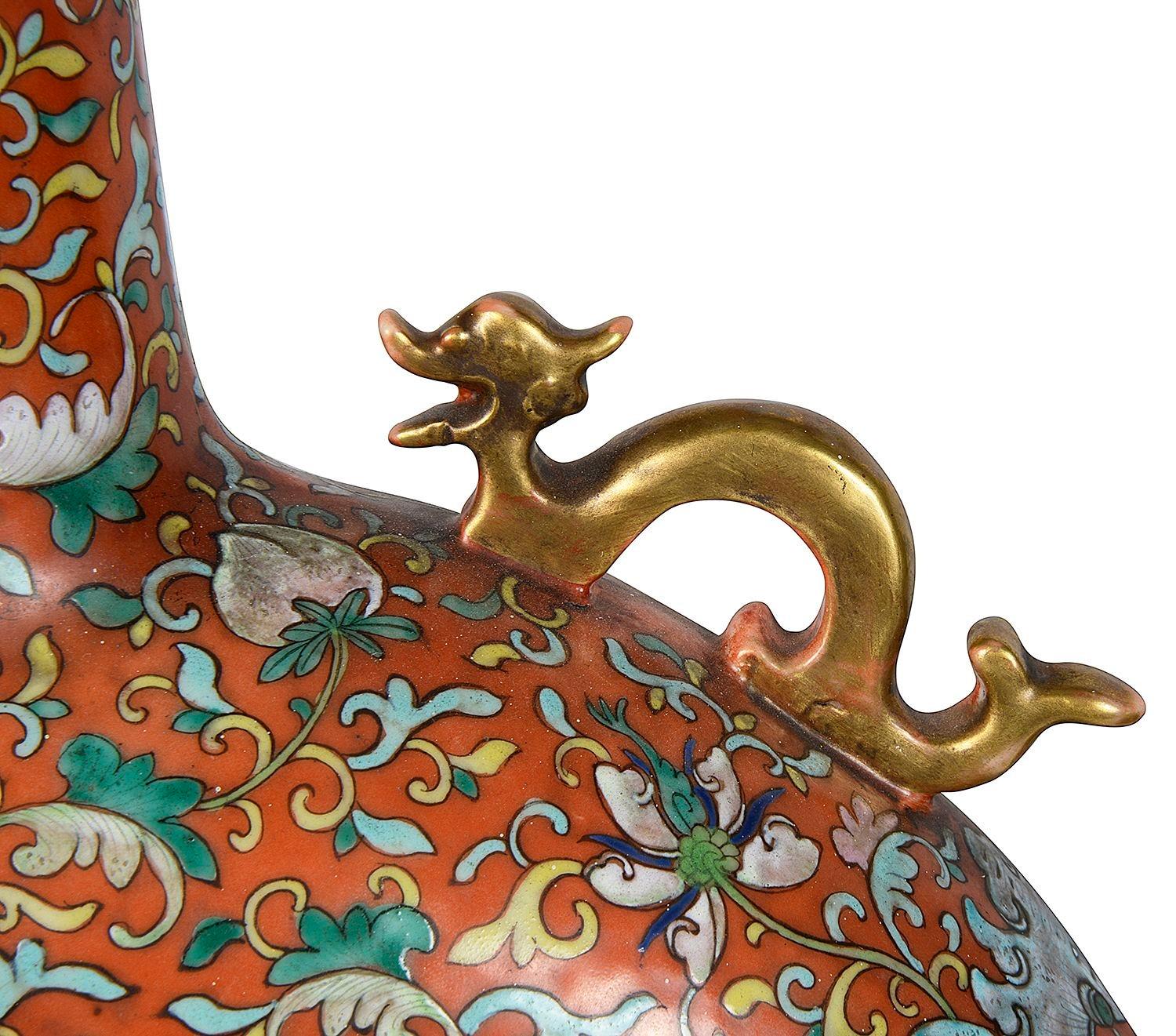 Ein sehr beeindruckendes Paar chinesischer Famille-Rose-Mondflaschen aus dem 19. Jahrhundert, jeweils mit klassischen Motiven, vergoldeten Schlangengriffen auf beiden Seiten und handgemalten Tafeln, die exotische Vögel, Blumen und Blütenbäume