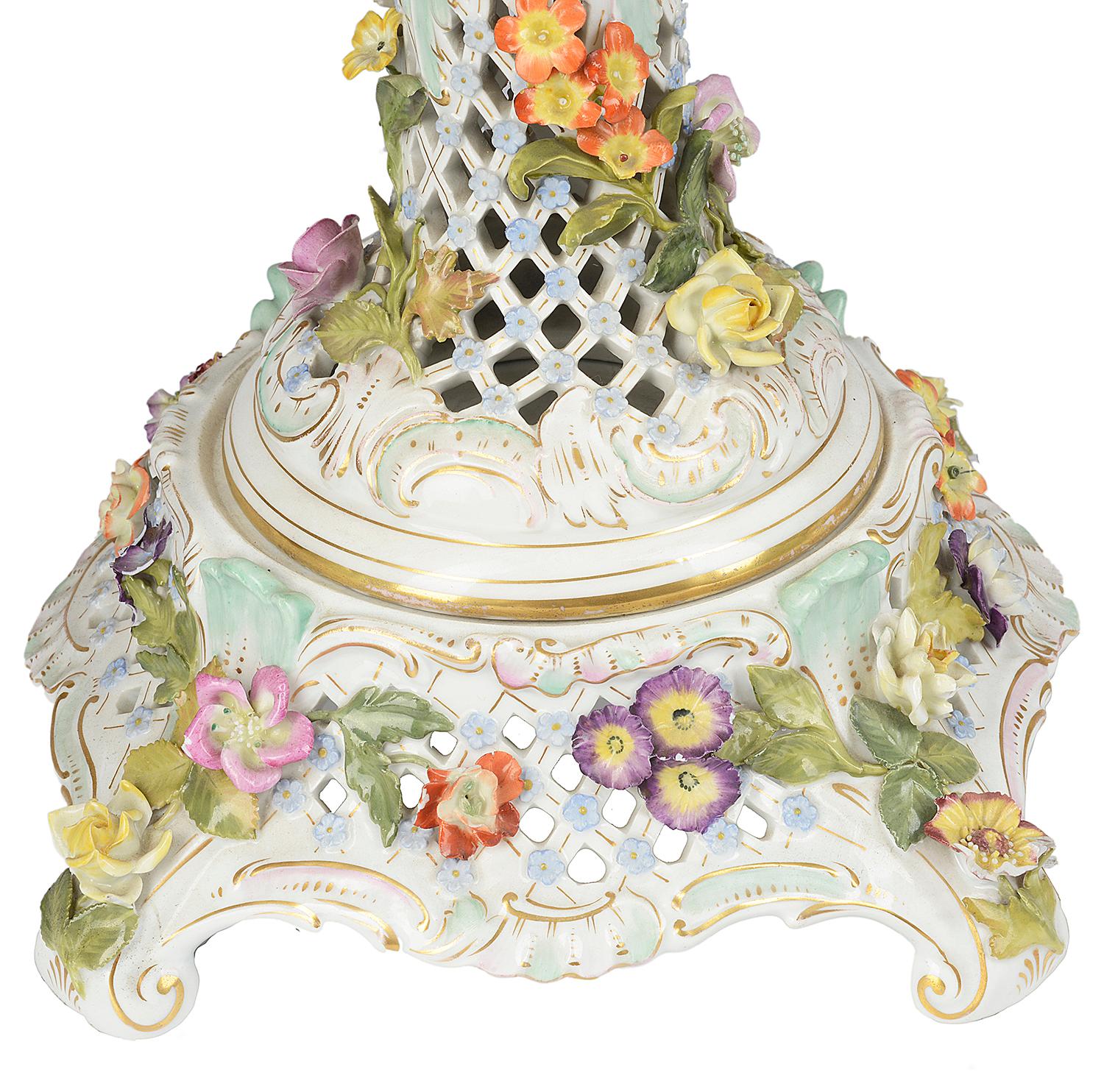 An impressive pair of Dresden style porcelain lidded comports, each with cherubs seated or climbing around the lids, crowns to each with family crests, beautiful colored flowers surrounding the vases and handles. Romantic scenes painted and pieced