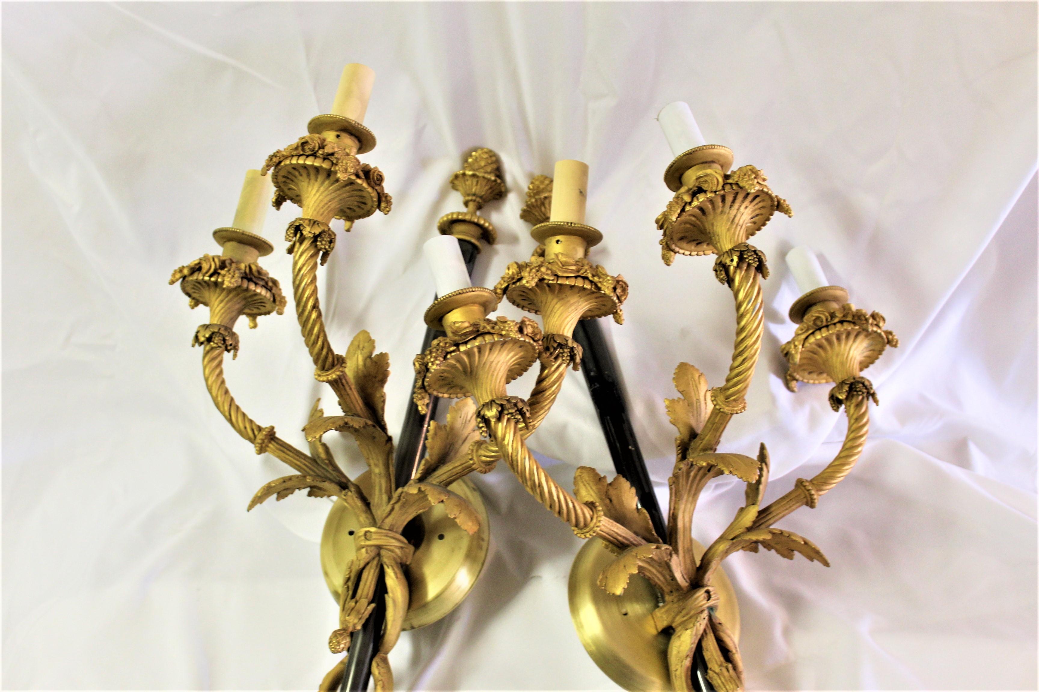 A Larger pair of Empire Looking style sconces  They are of hi-quality lost wax Bronze castings with fine detailing .  With polished 18-karat gold plated finish in Antique. Center shaft is steel in black powder coated finish. Wired and ready.