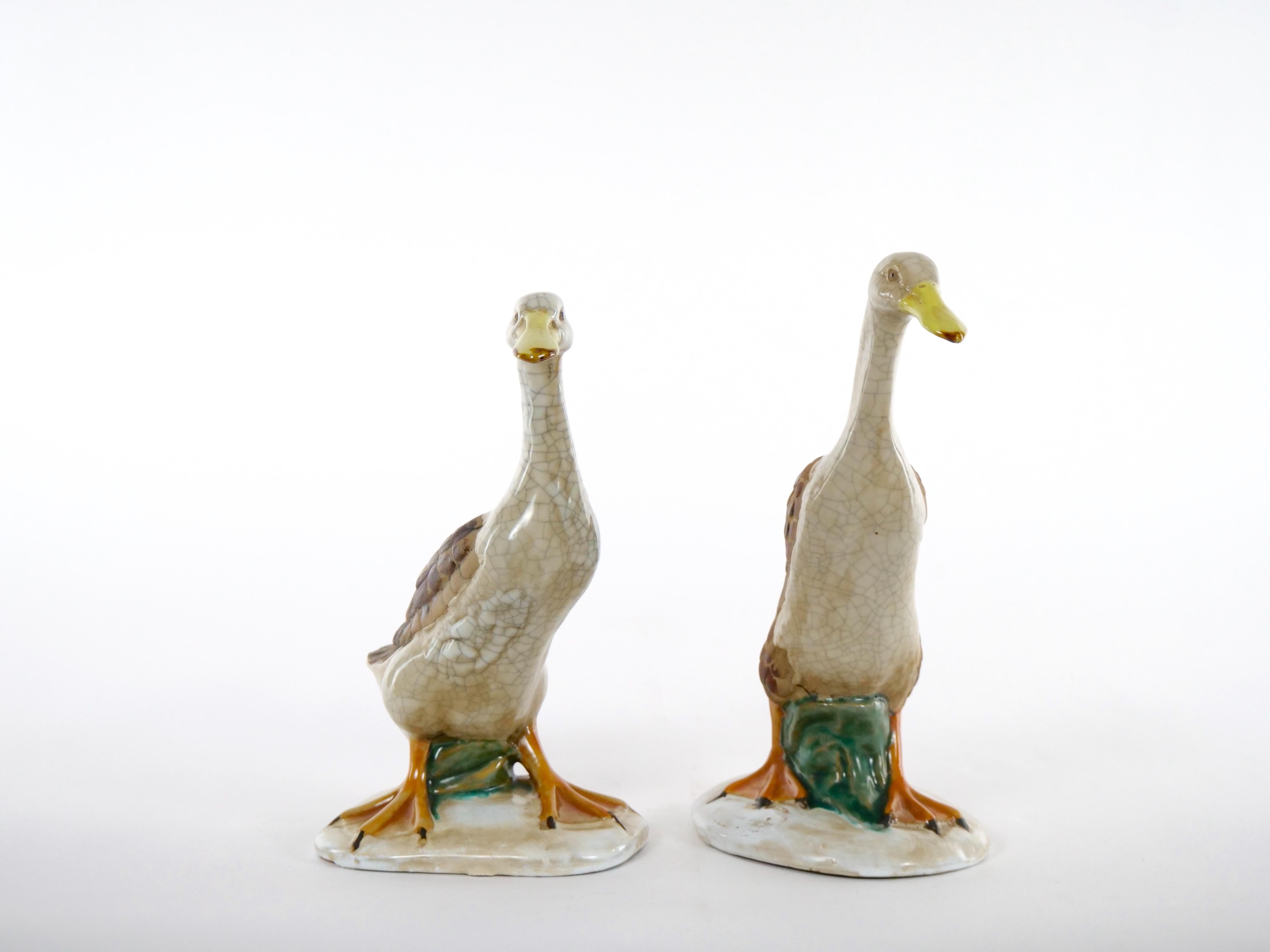 Beautiful English porcelain / terracotta hand painted and glazed decorated pair of decorative duck statues. This stunning large pair of English glazed porcelain tableware decorative ducks are executed in vibrant colors of orange , brown, beige,