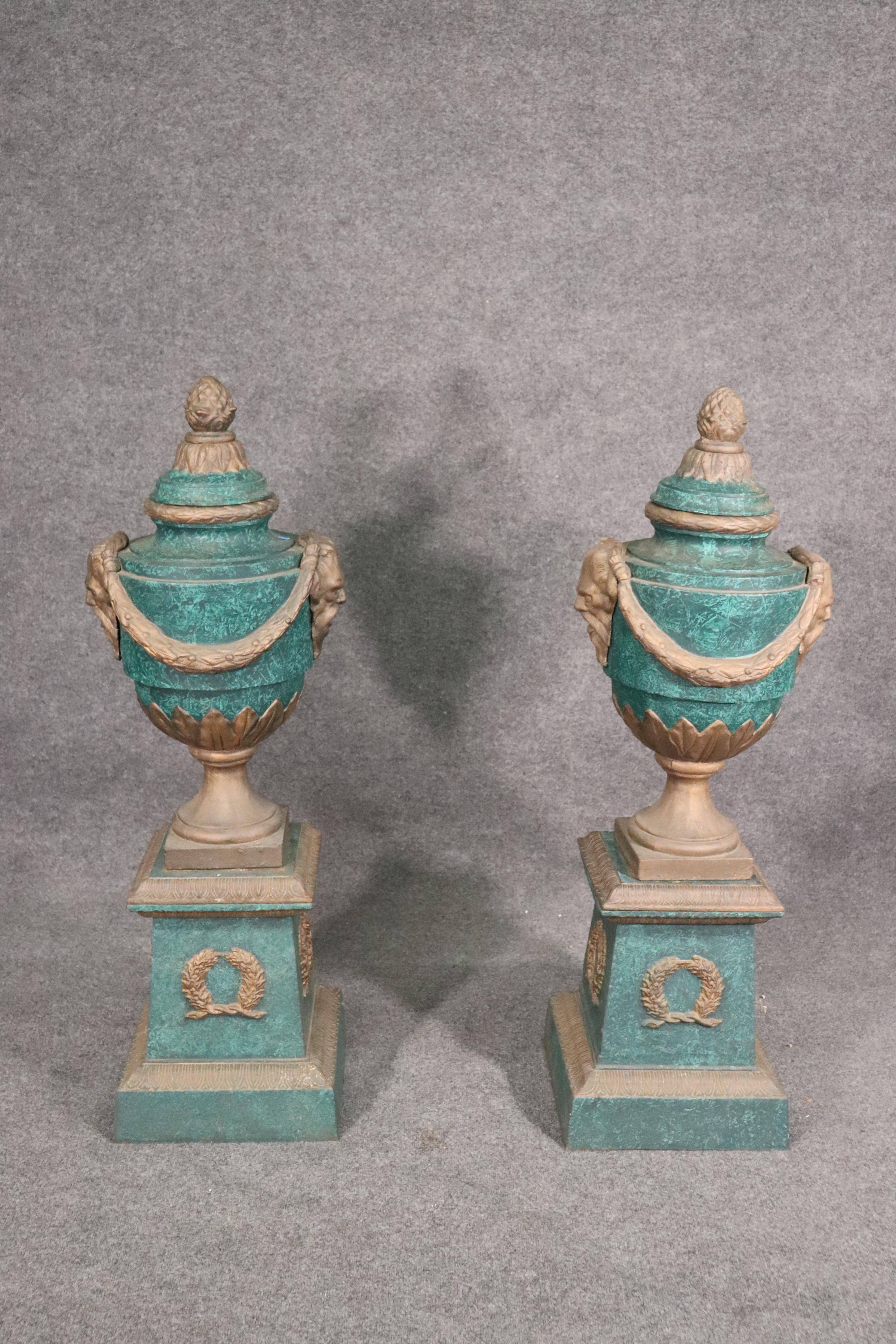 This large pair if antique 1900s era urns have been painted to look like they are made of malachite and bronze. These urns are large and come apart into many sections for delivery. The urns measure 50 tall x 14 .5 wide x 14.5 deep and are perfect