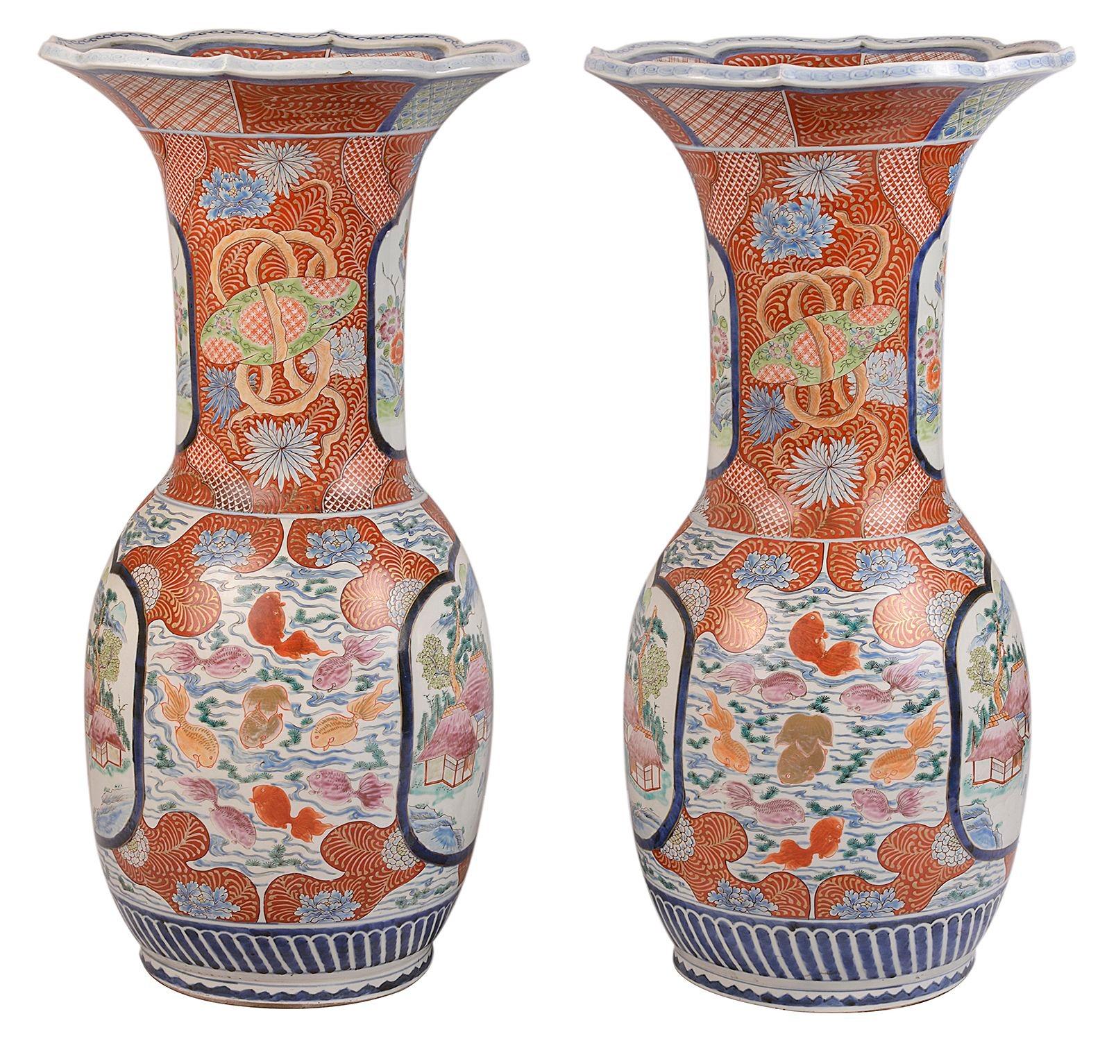 An impressive pair of late 19th century Japanese Kutani flare neck vases, circa 1890. Each with bold orange colouring to the classical motif decoration and inset hand painted panes depicting mountainous scenes with buildings among trees.
Signed to