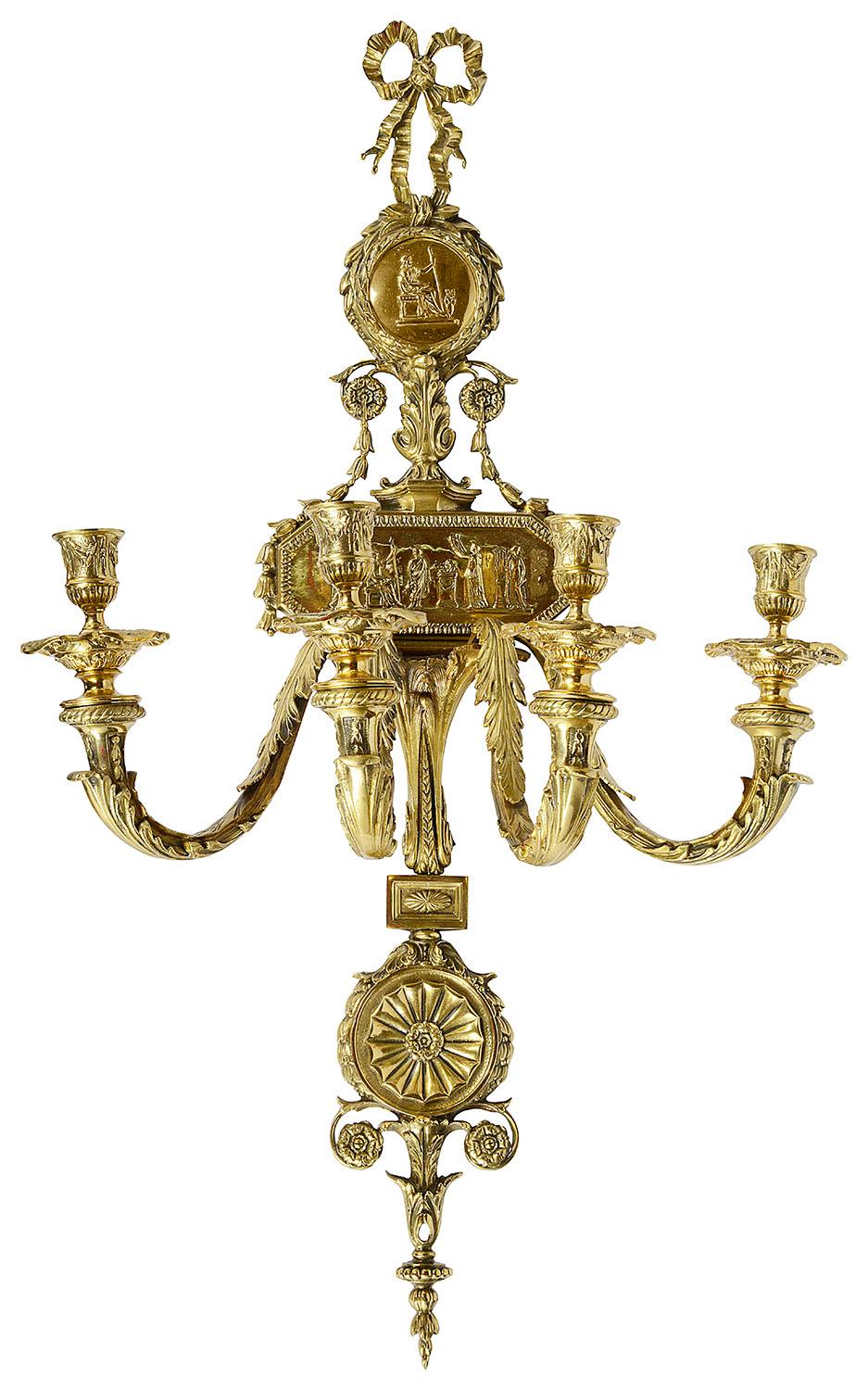 A very impressive pair of late 19th century French ormolu four branch wall lights, each with classical scenes depicted in the plaques, scrolling foliate, and ribbon decoration.