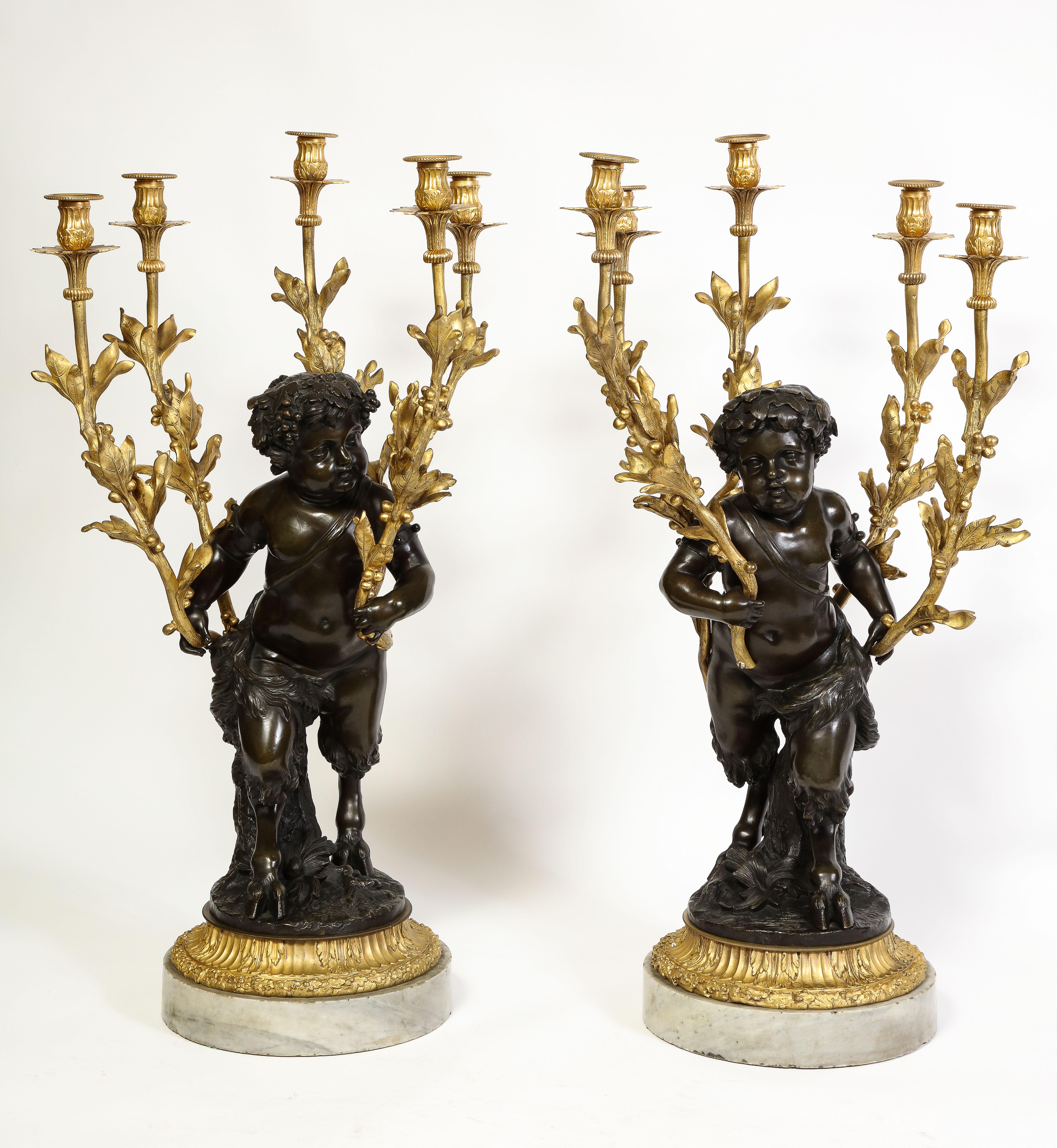 A Large Pair of antique French Louis XV/XVI Patinated & Doré Bronze Putti Form Candelabra on Marble Bases.  This Large Pair of 19th Century French Patinated and Doré Bronze Putti Form Multi-Light Candelabra on Marble Bases are masterpieces of