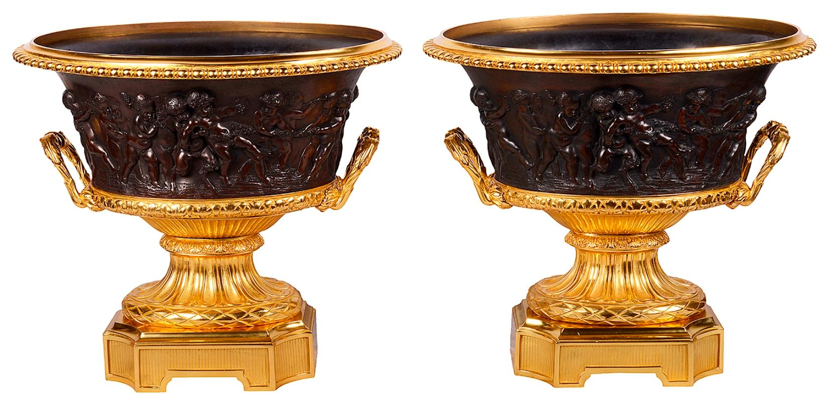 Paire très impressionnante d'urnes Campana en bronze doré et patiné du XIXe siècle. Chacune d'elles présente de merveilleuses scènes classiques de Bacchus Putti en bronze, reposant sur des piédestaux en bronze doré cannelé et ciselé, avec des