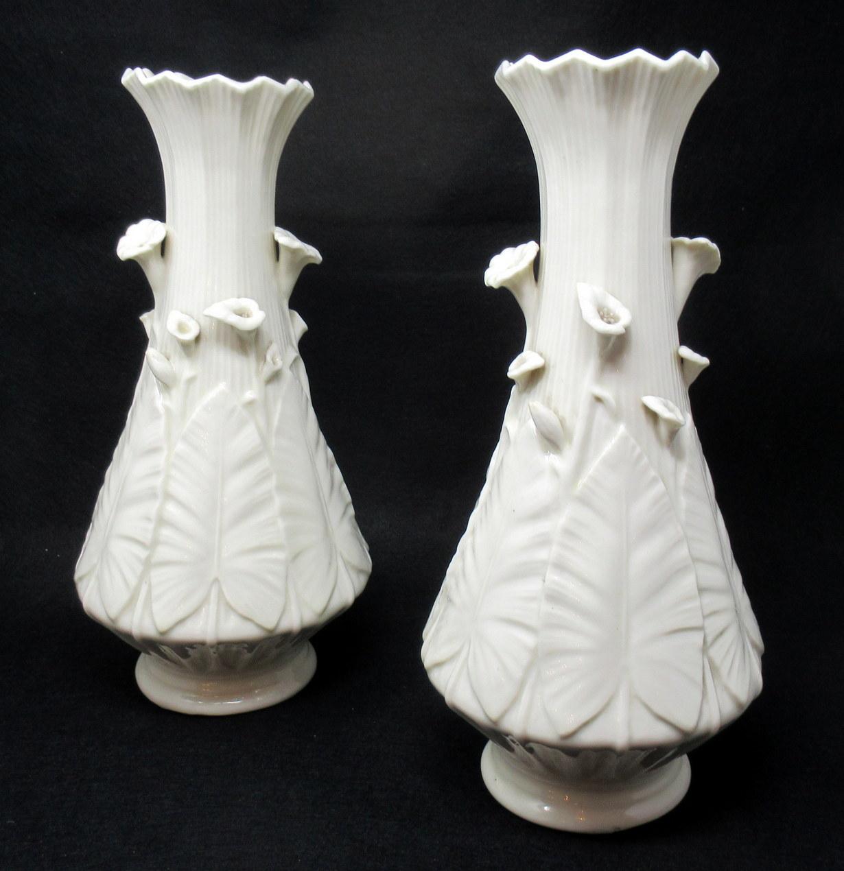 Stunning Rare Pair of Irish Belleek Porcelain Nile Vases of substantial proportions. First Black Mark for dates 1863 - 1891. 

Each leaf moulded body of bulbous outline with applied trumpet Cala Lily flowers in high relief. The tall slender flared