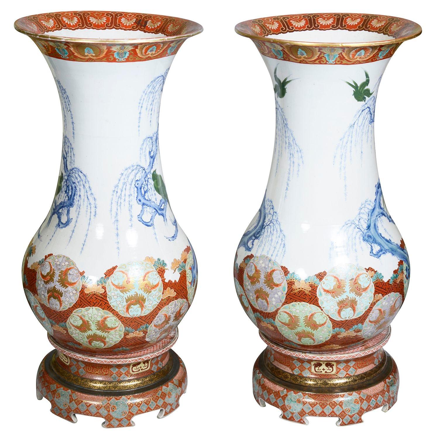 Una coppia di grandi vasi di porcellana giapponese Imari Porcelain di grande effetto decorativo su supporto. Ciascuna di esse presenta una meravigliosa decorazione a motivi classici sui bordi superiore e inferiore. Con alberi di salice e colombe che