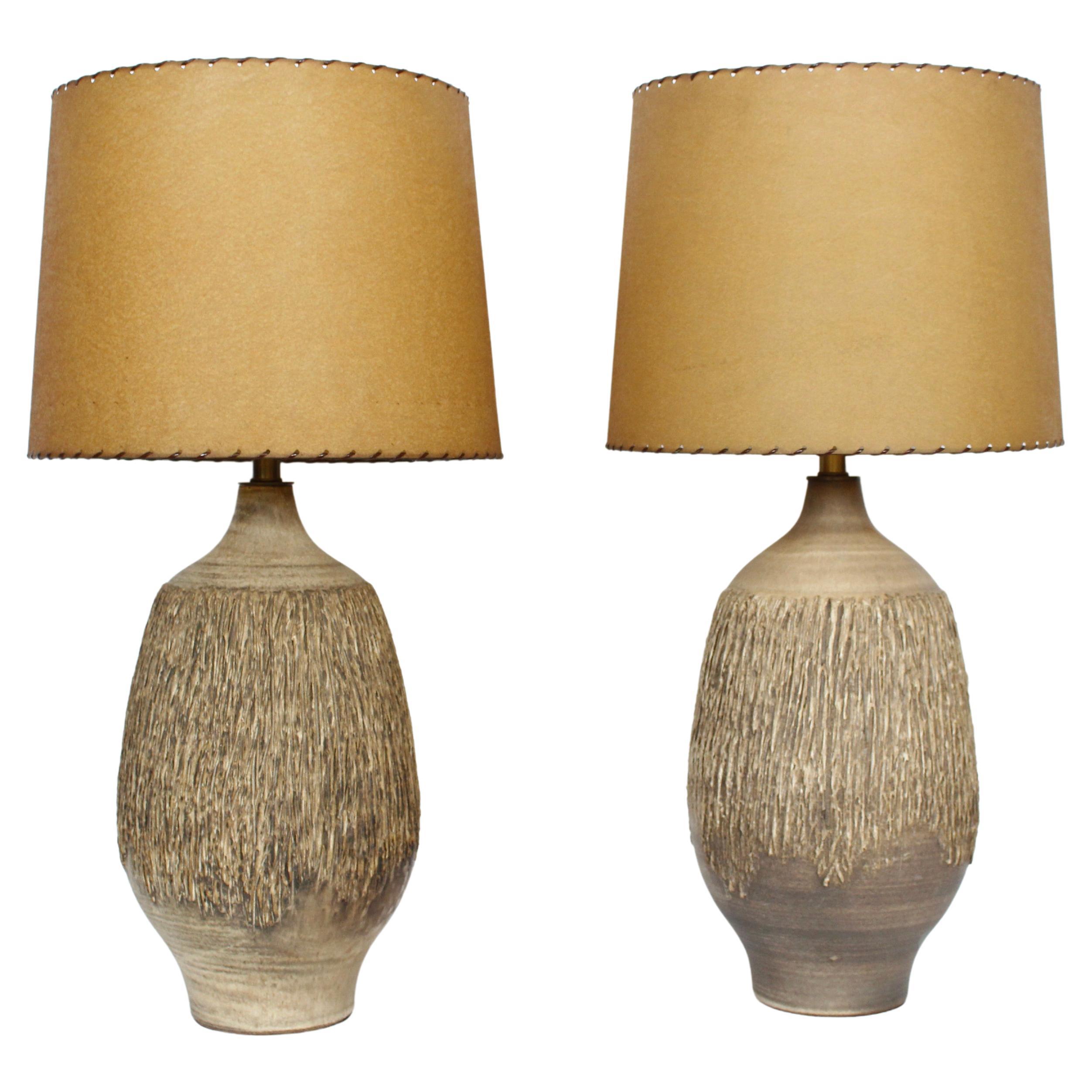 Pair Lee Rosen for Design Technics Hand Thrown Glazed table lamps, 1950's. Featuring tall earthen organic matte bottle forms with glazed Taupe, Coffee, natural Cream tones and hand applied textural vertical bark like detail. Brass neck. 23 to top of