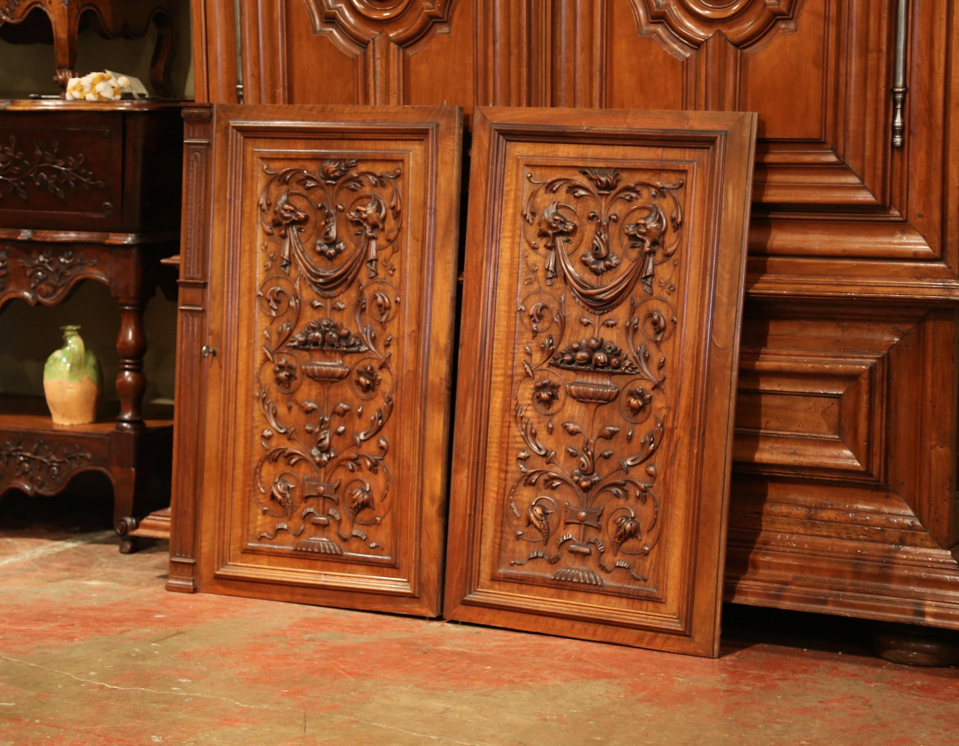 Use these fruit wood doors as closet doors or hang them as decorative art; made in northern France, circa 1870, each antique door has exquisite hand-carved motifs including, dog figures, fruit baskets, floral and foliage decor. These doors are in