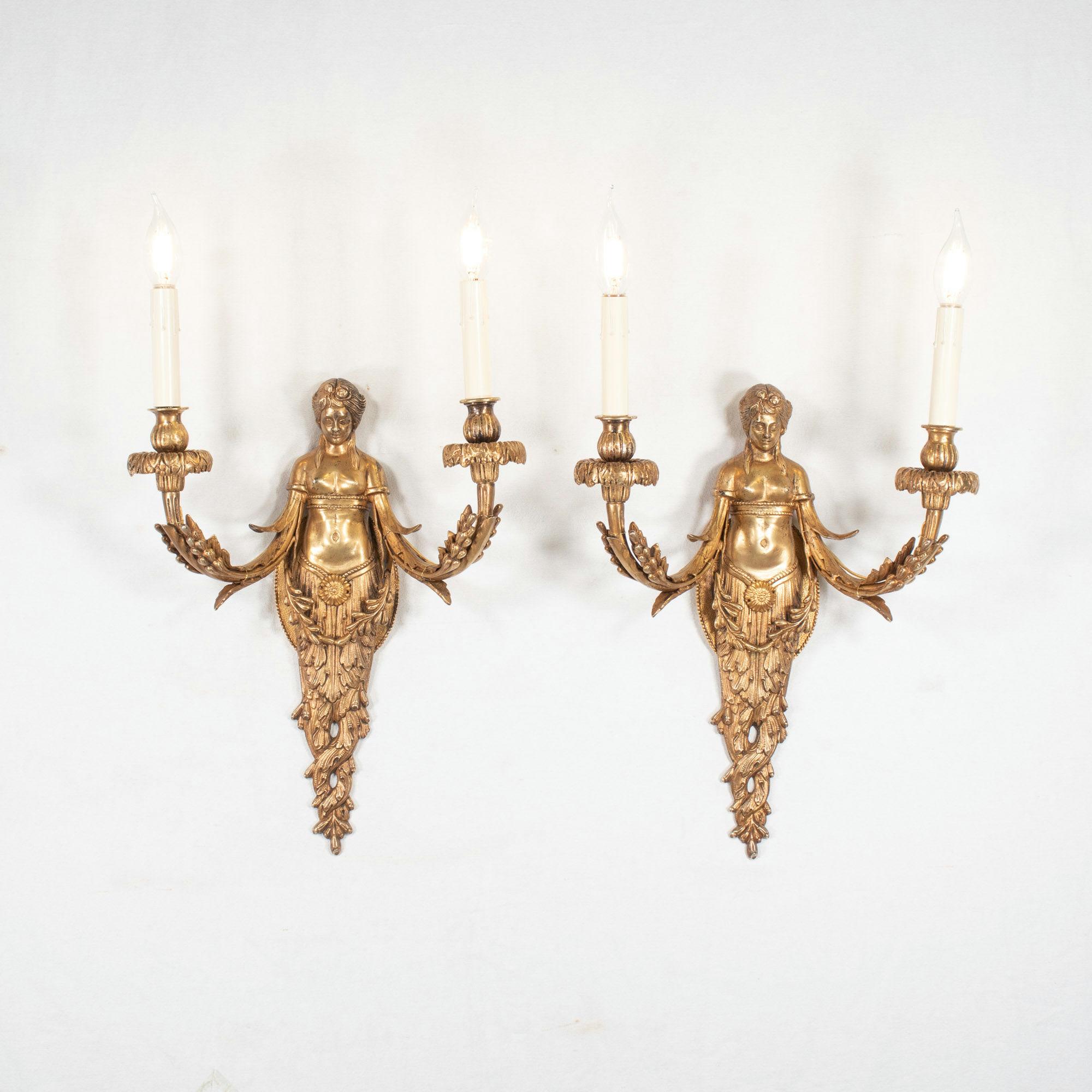 Cette paire d'appliques en bronze doré de style Empire français, datant d'environ 1900, représente la figure mythologique Acantha, une nymphe aimée du dieu Apollo. Selon la légende, Apollo a transformé l'Acantha en plante acanthe, un motif
