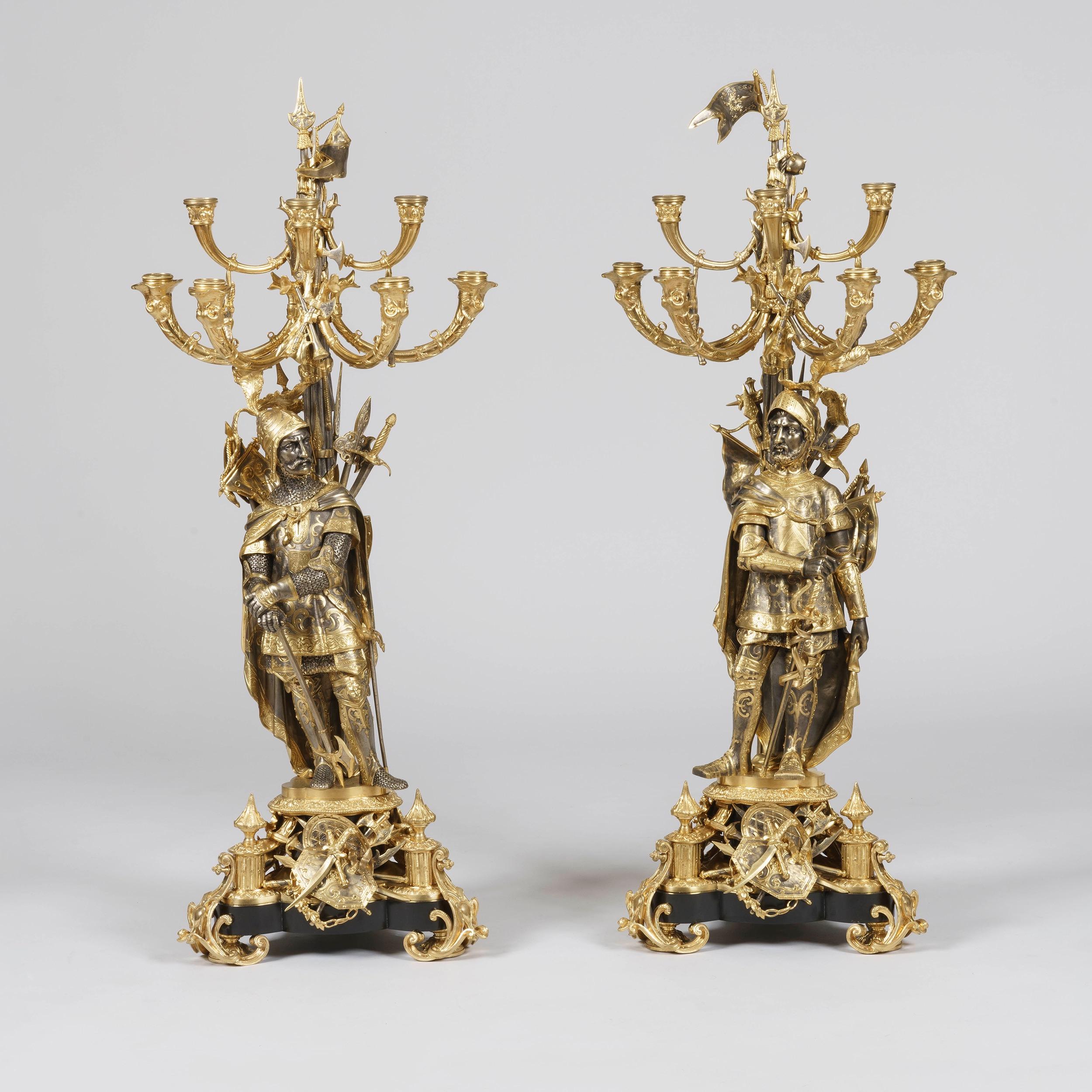 An August Pair of Napoleon III Silvered and Gilt Bronze Candelabra

Rising from sumptuous scrolling ormolu tripod bases incorporating a slate support and exquisite military regalia; the chivalrous men, one holding a sword and the other his axe,