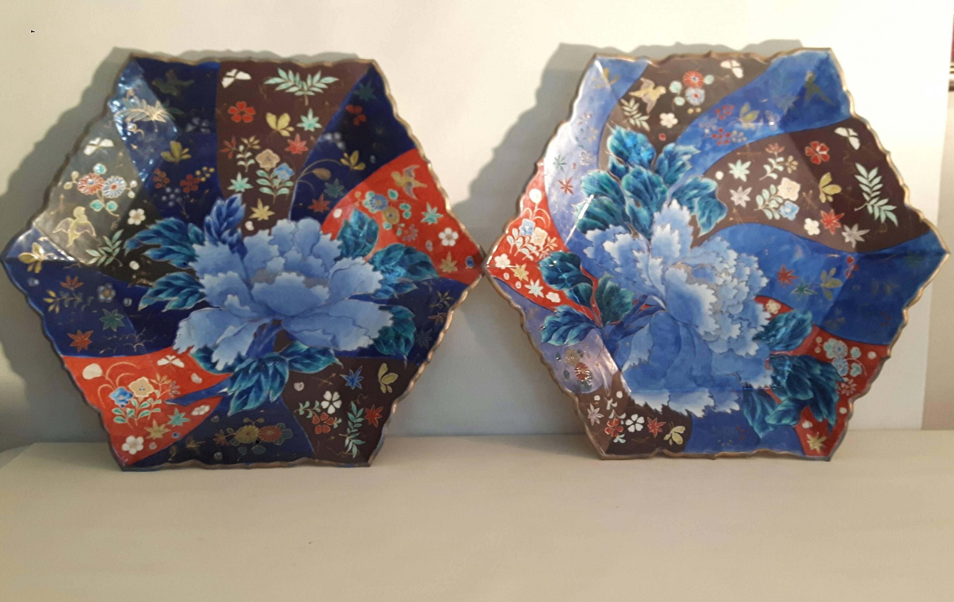 A wonderfully designed and decorated pair of Japanese Imari dishes, hexagonal shaped, signed by artists Crouncha. Decorated with a blue peony (a symbol of immortality) and various flowers in a swirl of richly colored bands.
