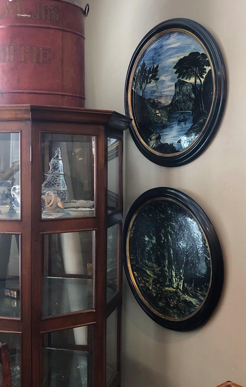 Each well-executed plaque of impressive scale depicting a moody forest scene and a tranquil lake setting; all within custom ebonized moulded frames with giltwood slips; excellent antique condition with no chips or cracks to ceramic.